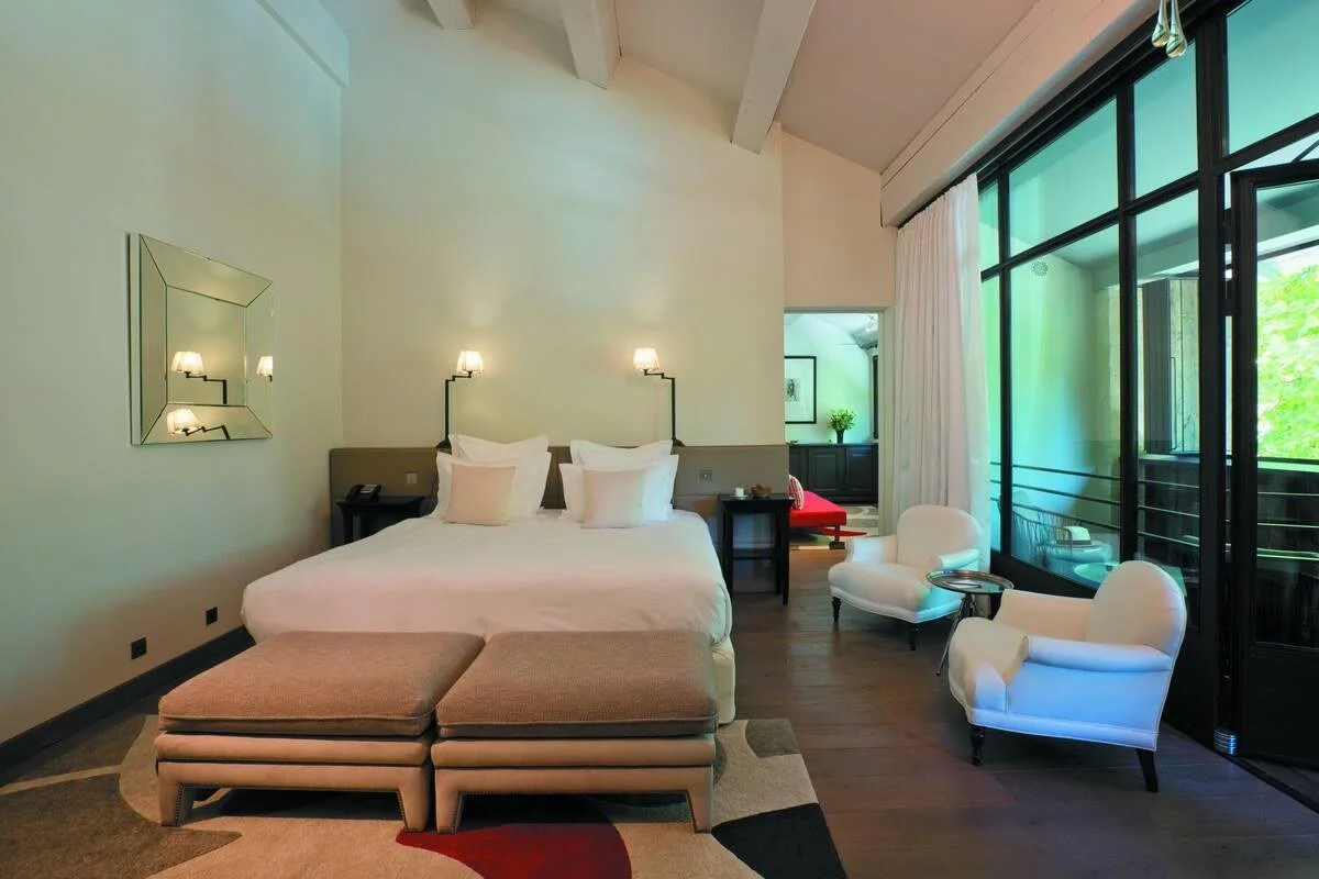 Suite bedroom at Domaine de Manville with a vaulted ceiling and steel framed doors onto a private terrace.