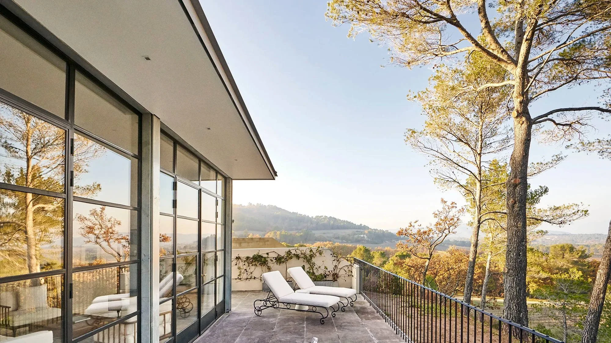 Private suite terrace at Villa La Coste with loungers and a view across the Luberon countryside in Provence.