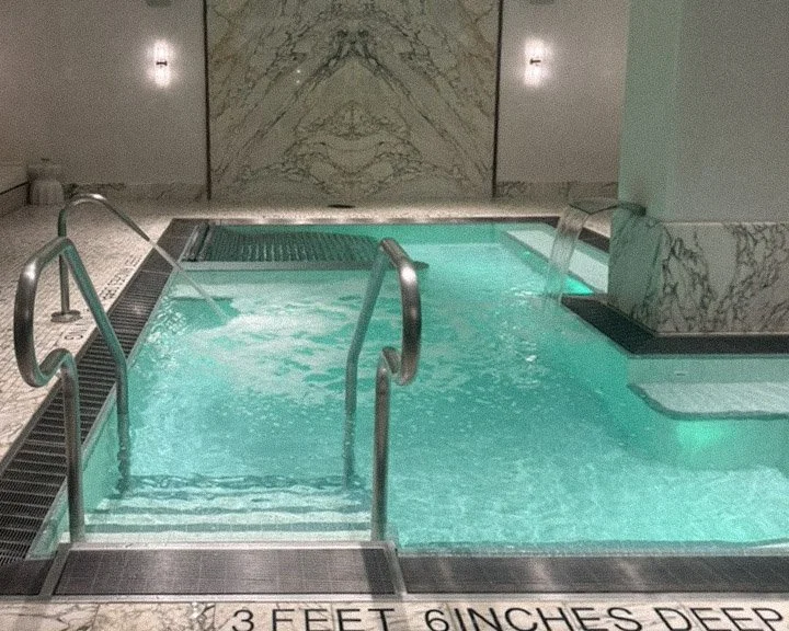 Piscina subterránea cubierta de hidroterapia con paredes de mármol en el Spa Fouquet's de Nueva York, en Tribeca
