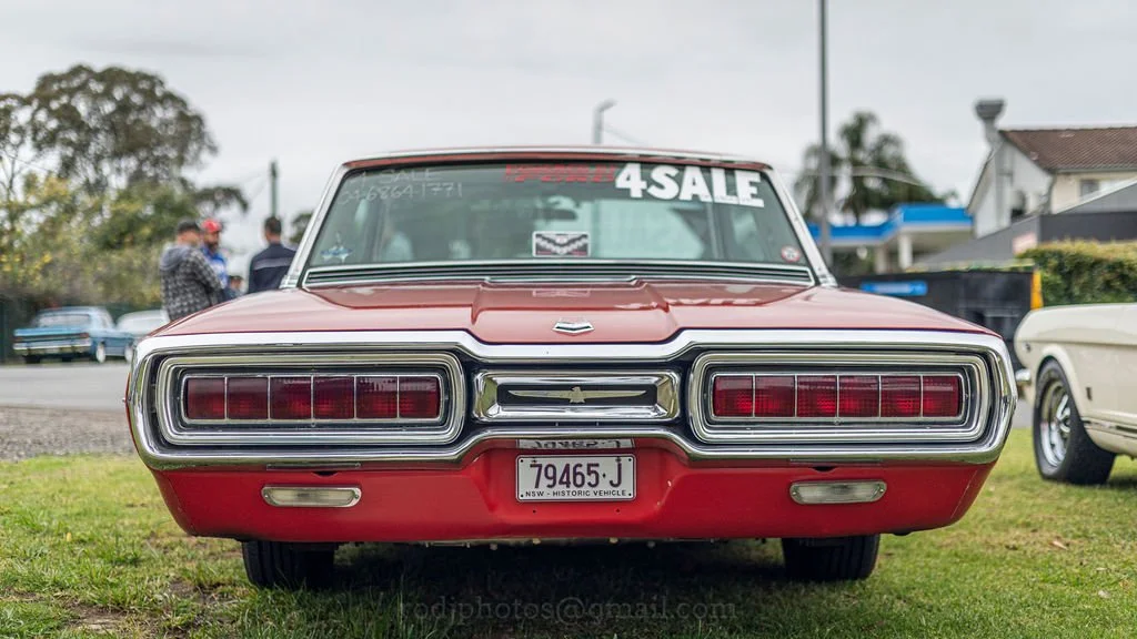 Front view of a classic red 1960s car with a '4 SALE' sign on the windshield.