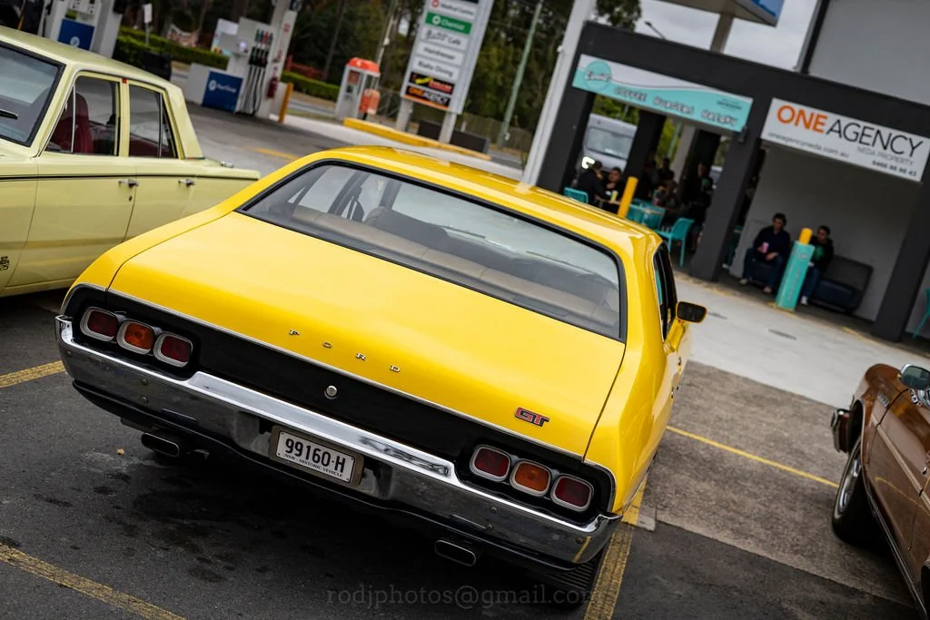 Rear view of a yellow vintage Ford GT car parked in a parking lot.