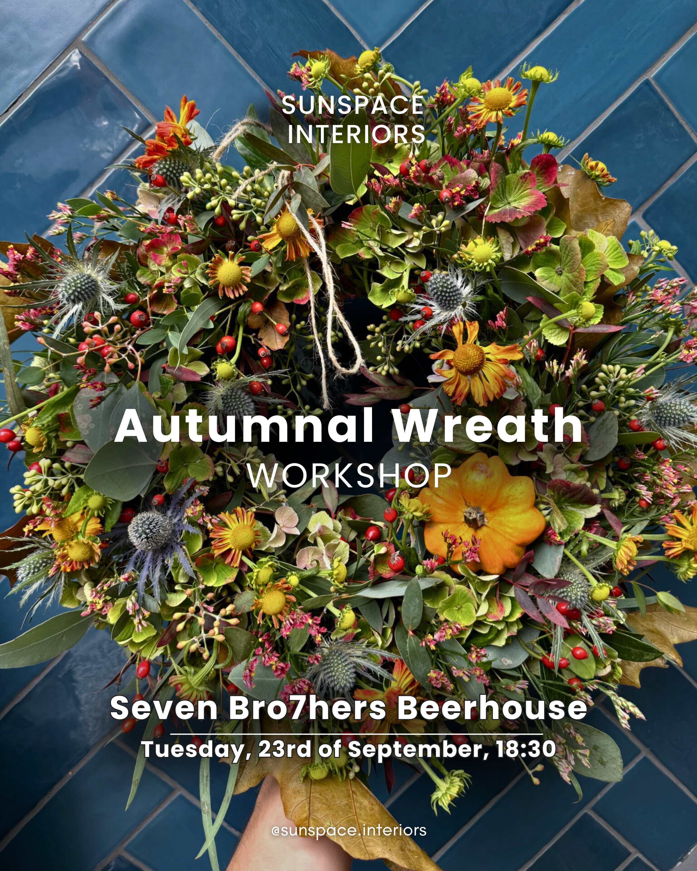 A colorful autumnal wreath made of flowers, leaves, and berries, with a pumpkin, on a tiled floor, promoting an autumn wreath workshop at Seven Bro7hers Beerhouse.