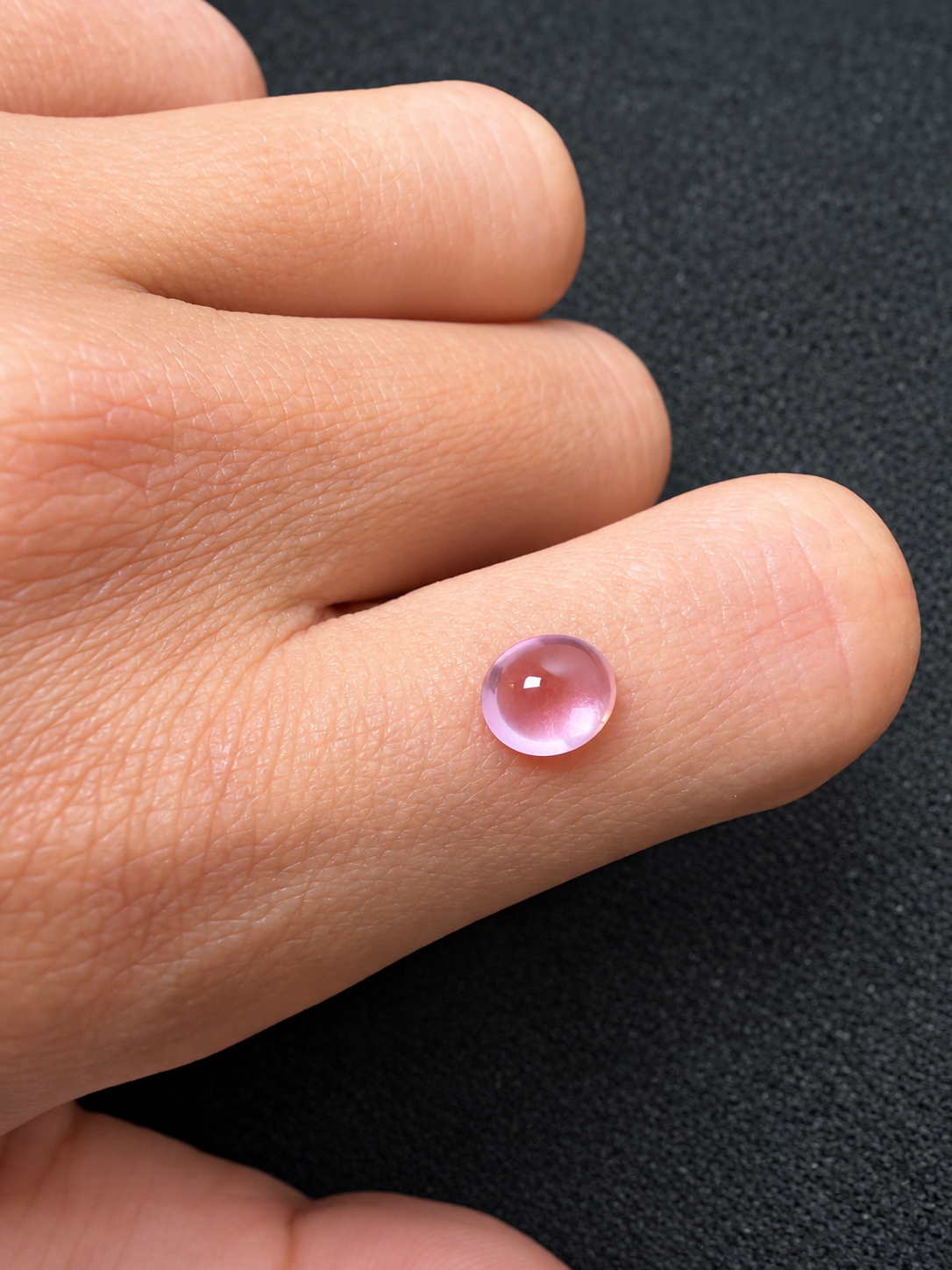 Polished Pink Cabochon on Finger.png