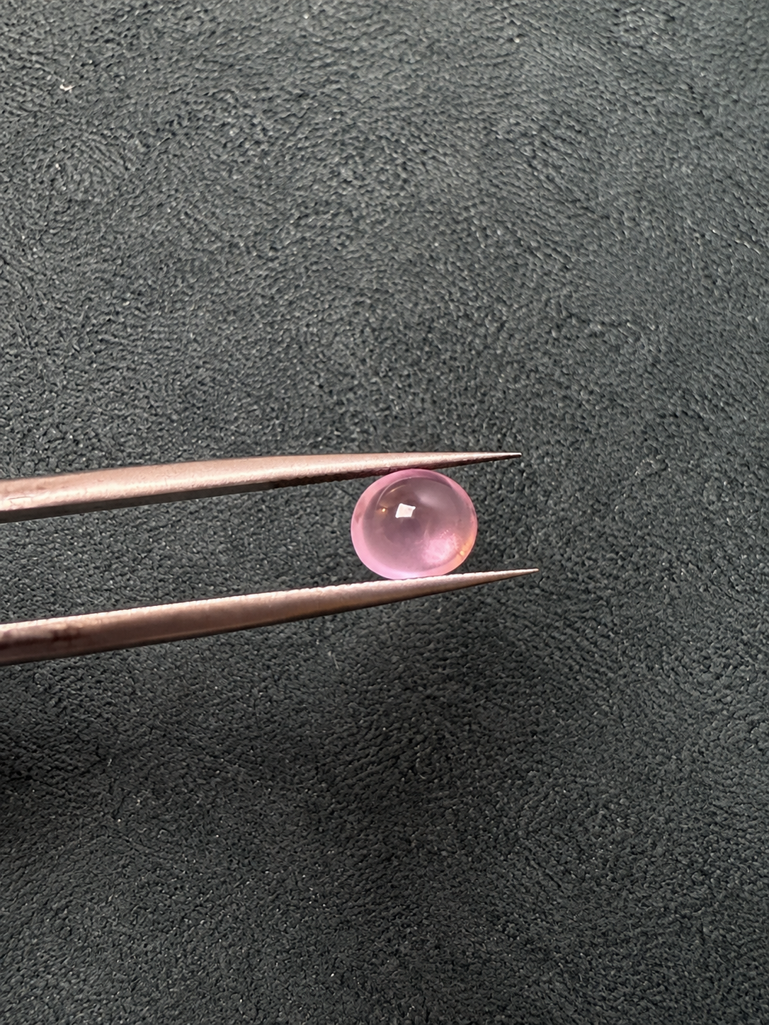 Baby Pink Spinel Cabochon in Tweezers.png