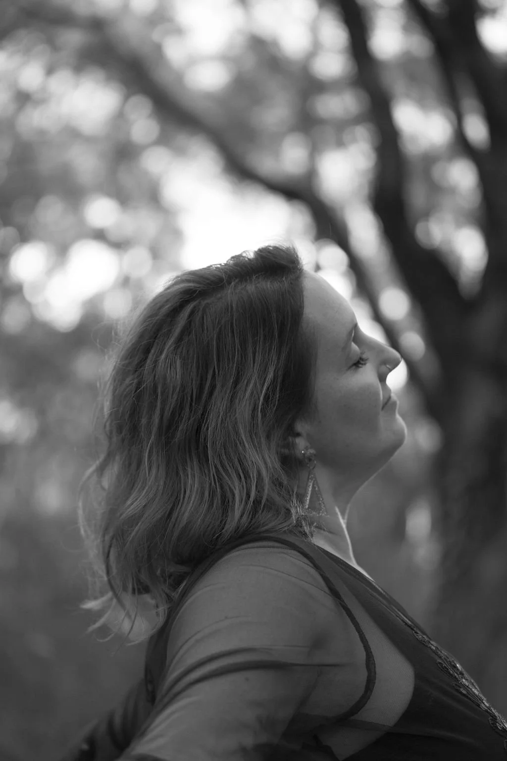 Wild & Sacred Feminine Embodiment Coaching black & white headshot of Camilla smiling with her eyes closed