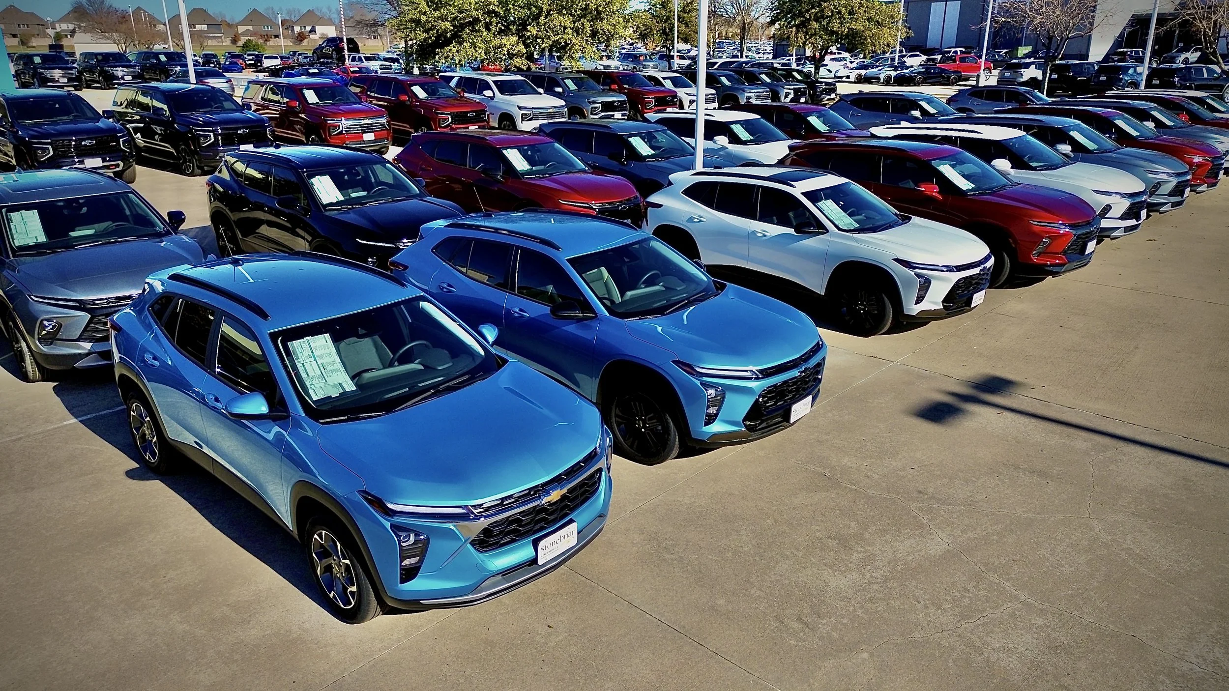 Aerial view of car dealership lot with rows of new SUVs
