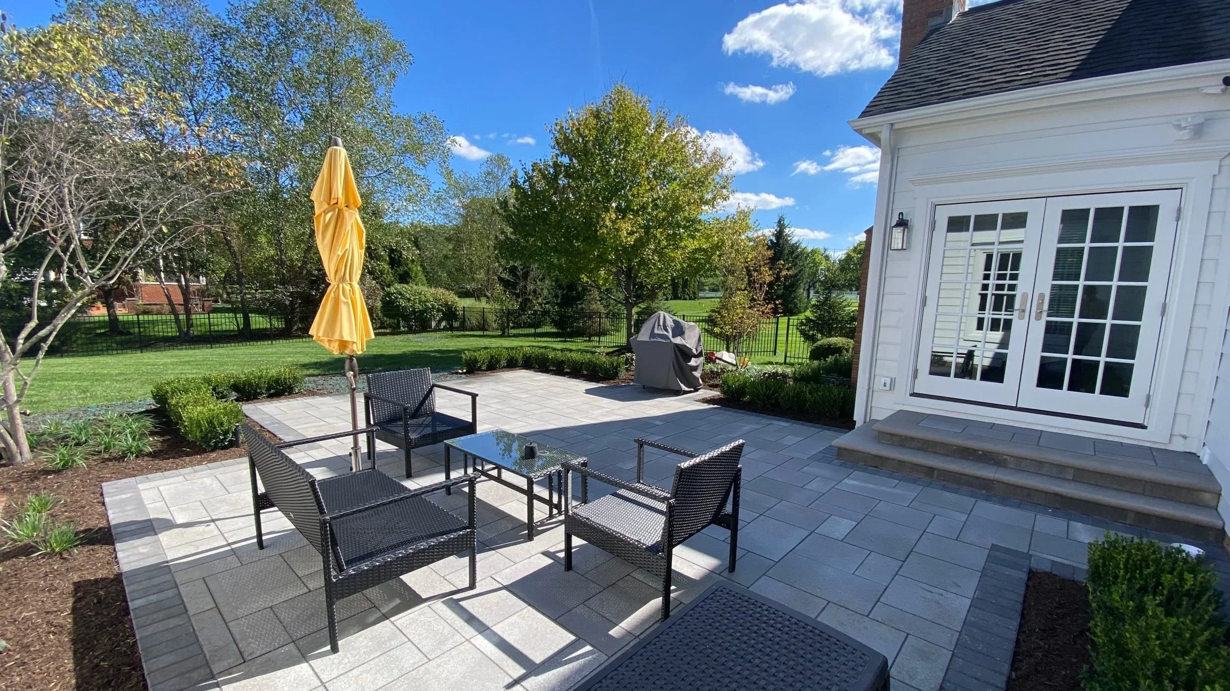 Unilock Umbriano paver patio with Indiana limestone steps. Buxus 'Faulkner' with Liriope spicata.