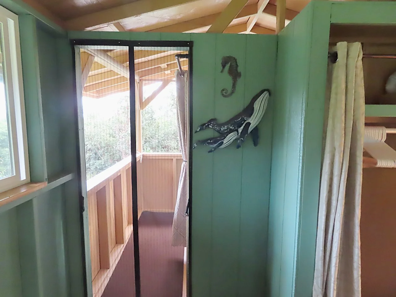 Screened doorway onto the upstairs lanai and bathroom from the bedroom. 