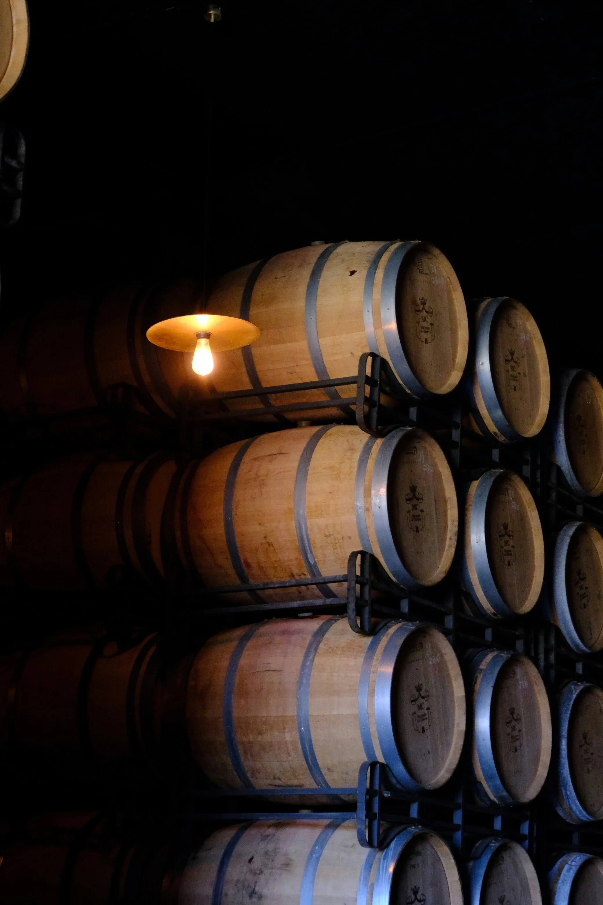 Oak wine barrels aging in a dark wine cellar