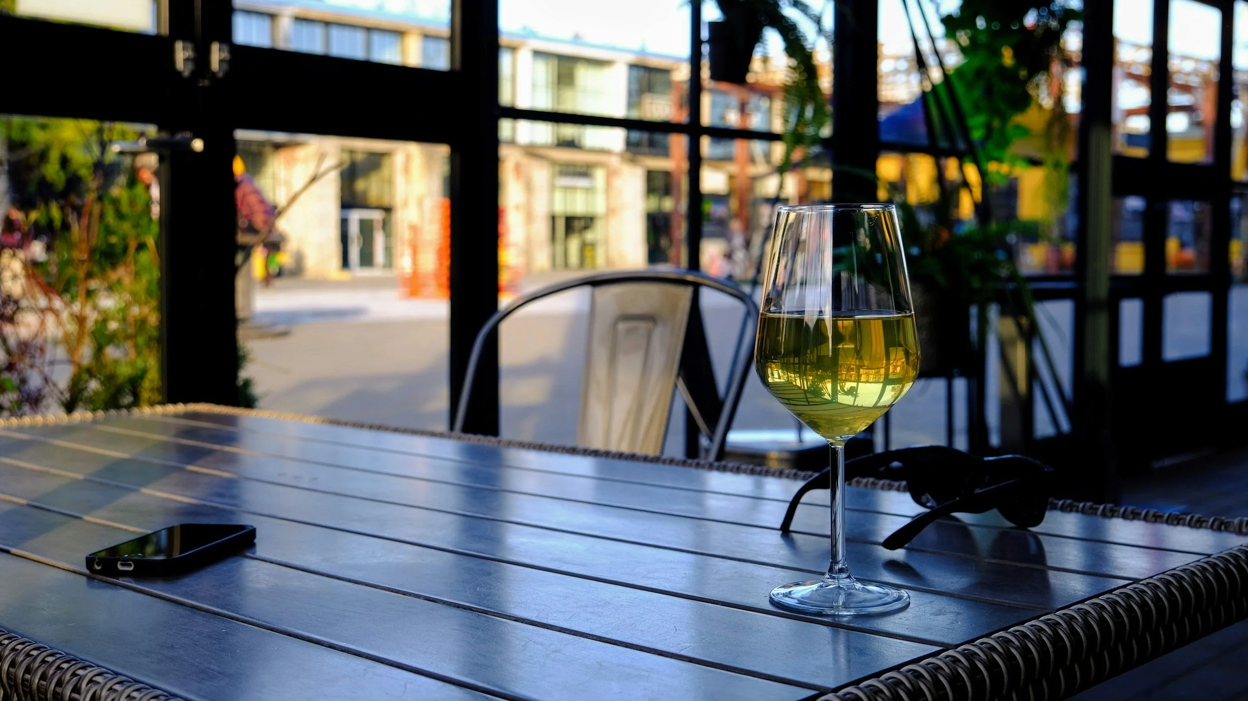 Glass of white wine on an outdoor restaurant table during an evening dining experience.