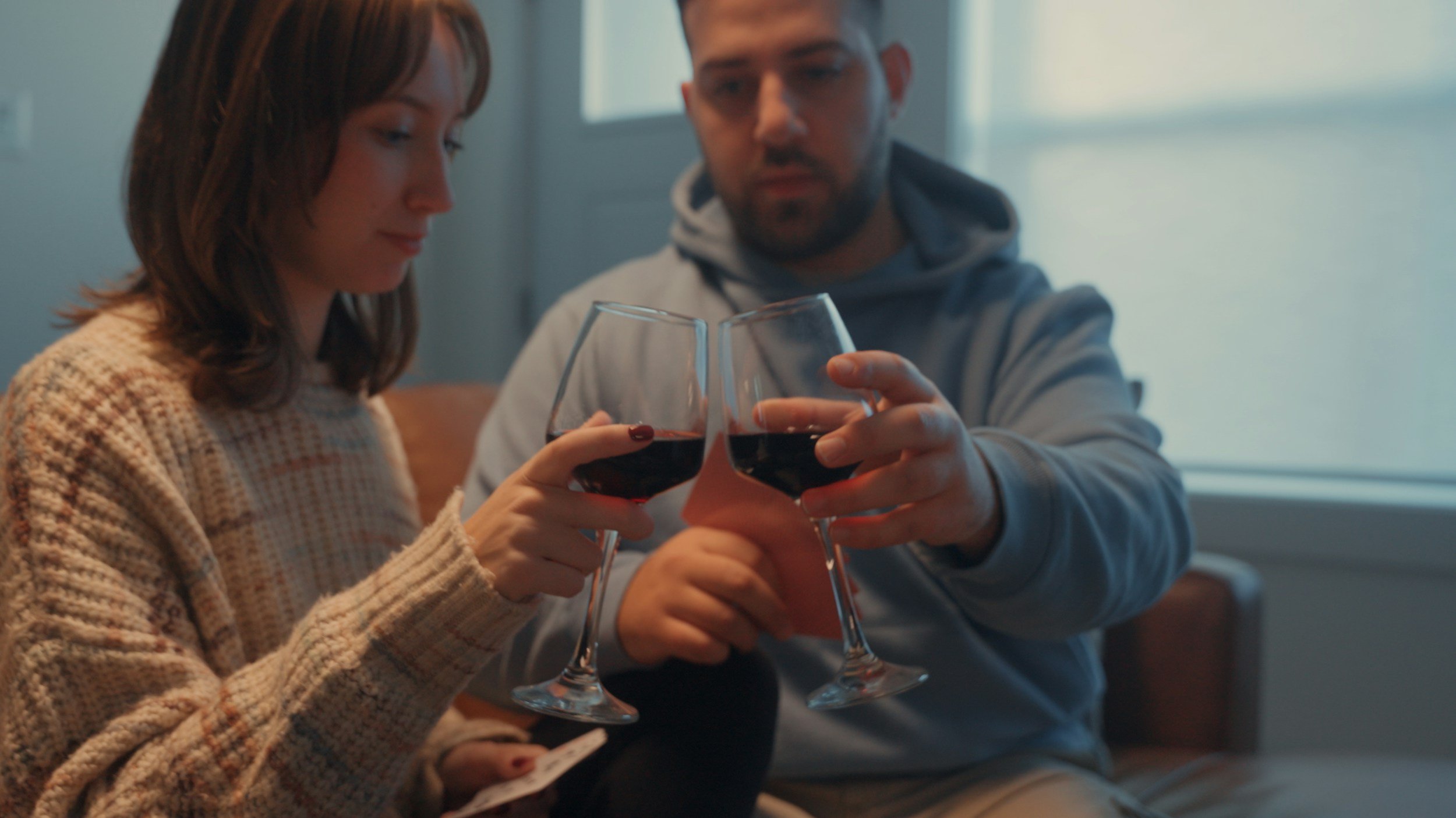 Two people enjoying wine together at home during a virtual wine tasting experience