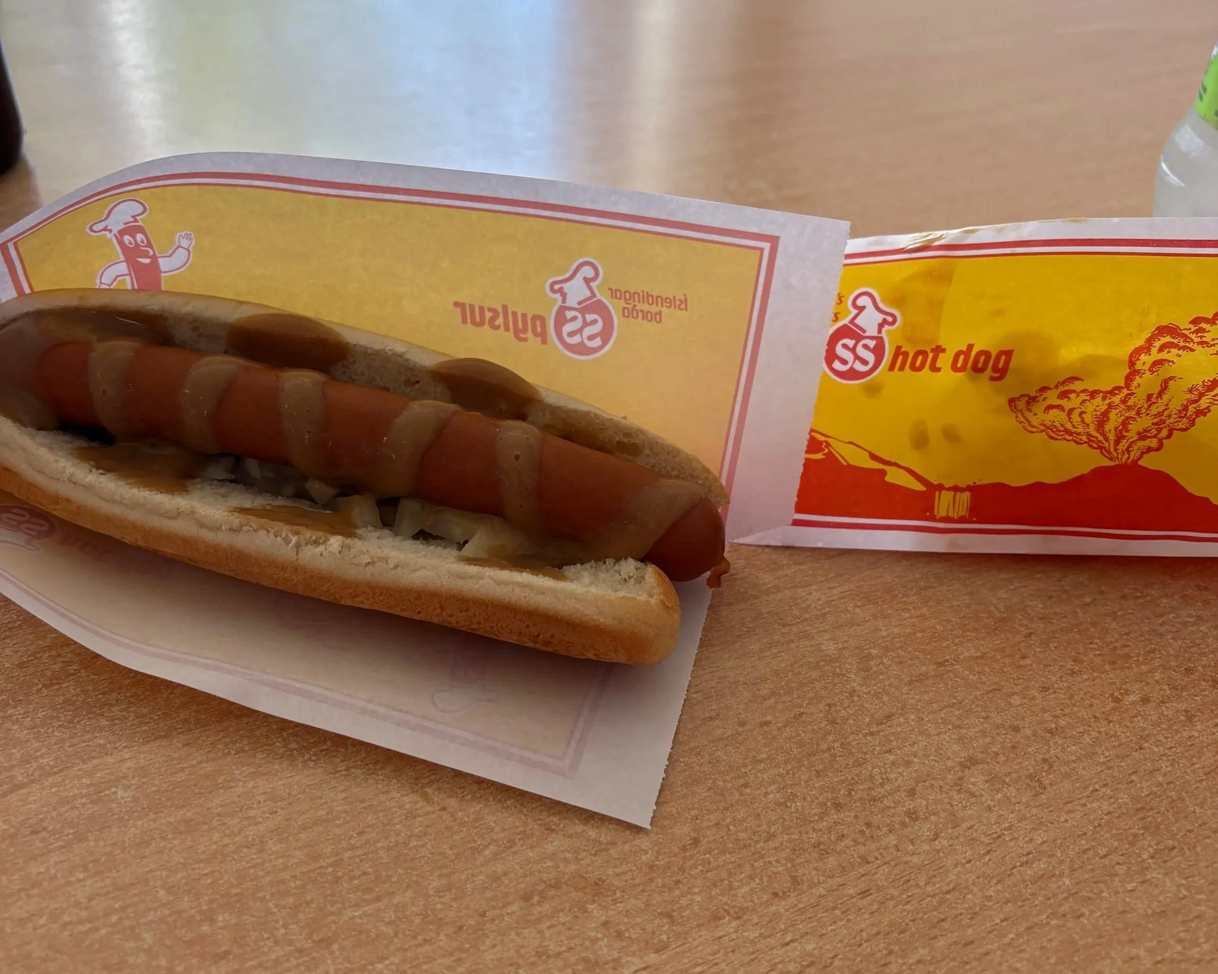 Traditional Icelandic hot dog topped with sweet brown mustard, remoulade, ketchup and onions from a popular Icelandic hot dog stand.
