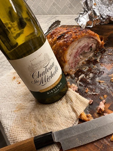 Bottle of Riesling next to grilled porchetta.
