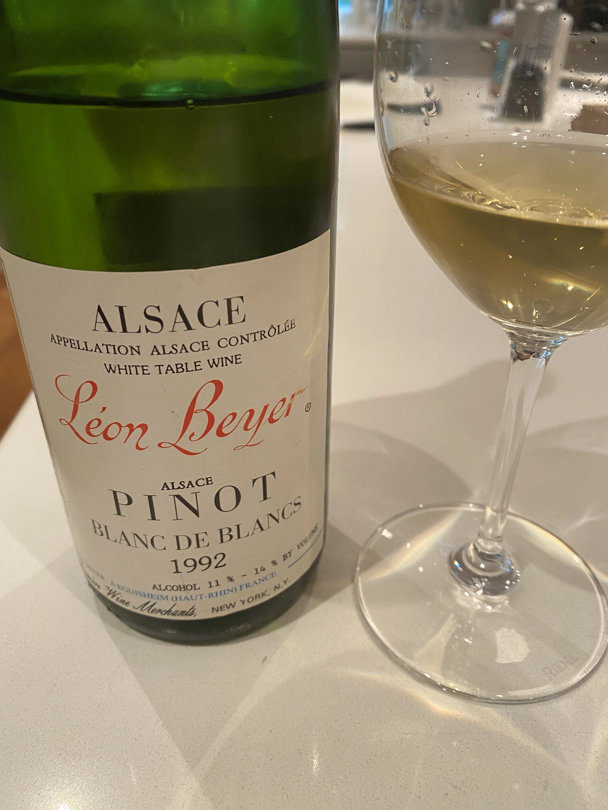 Bottle of Alsace Pinot Blanc served alongside a glass of white wine, highlighting one of the versatile and food-friendly wines of France's Alsace region