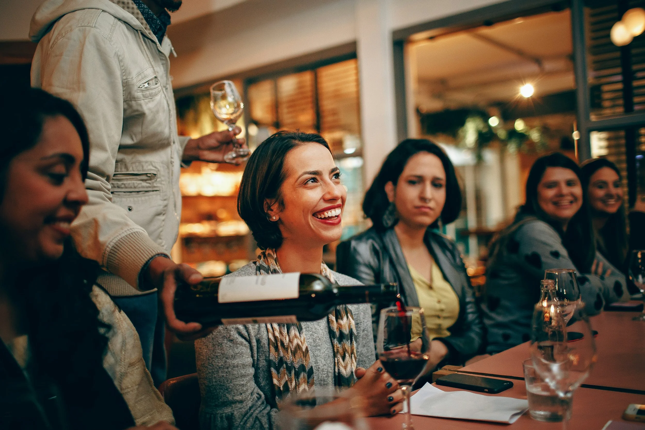 Guests enjoying conversation and asking questions during a guided home wine tasting experience.