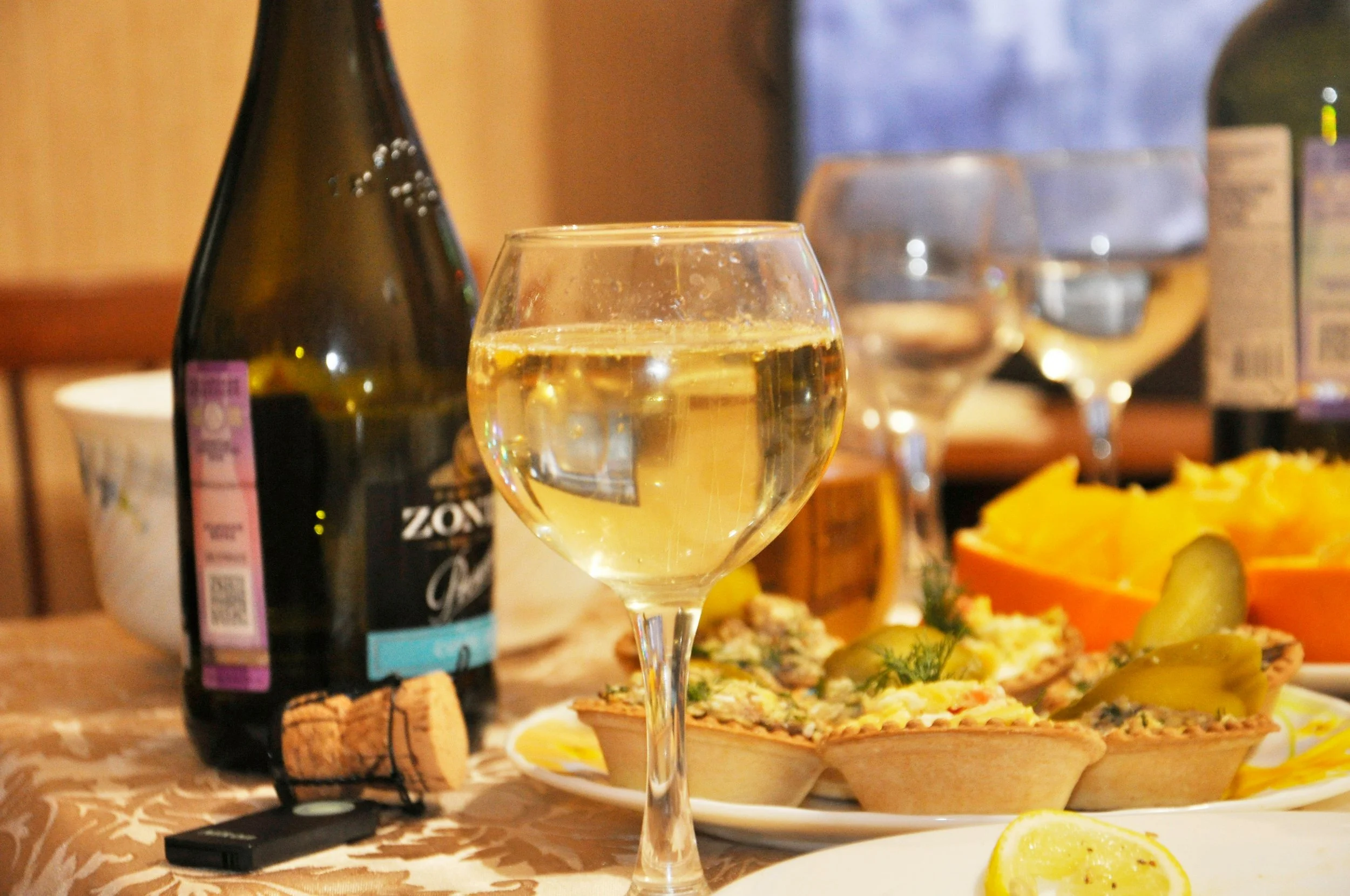 Glass of white wine served with appetizers and light bites during a casual wine and food pairing gathering