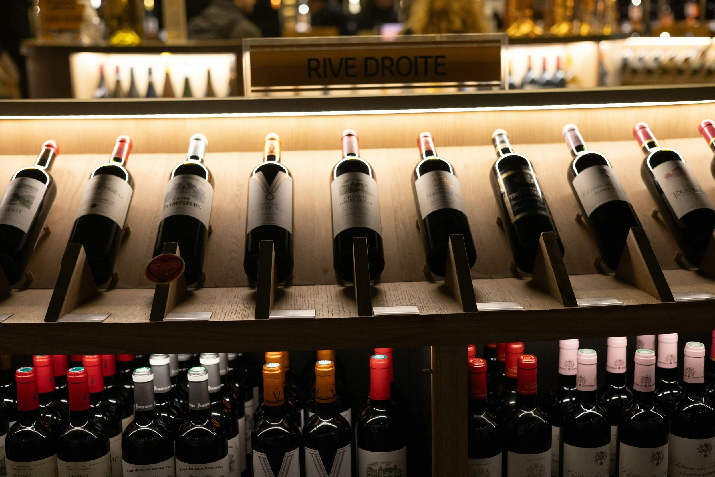 Wine bottles displayed on retail shelves, illustrating how Alsace wines often compete for attention among more familiar French wine regions.