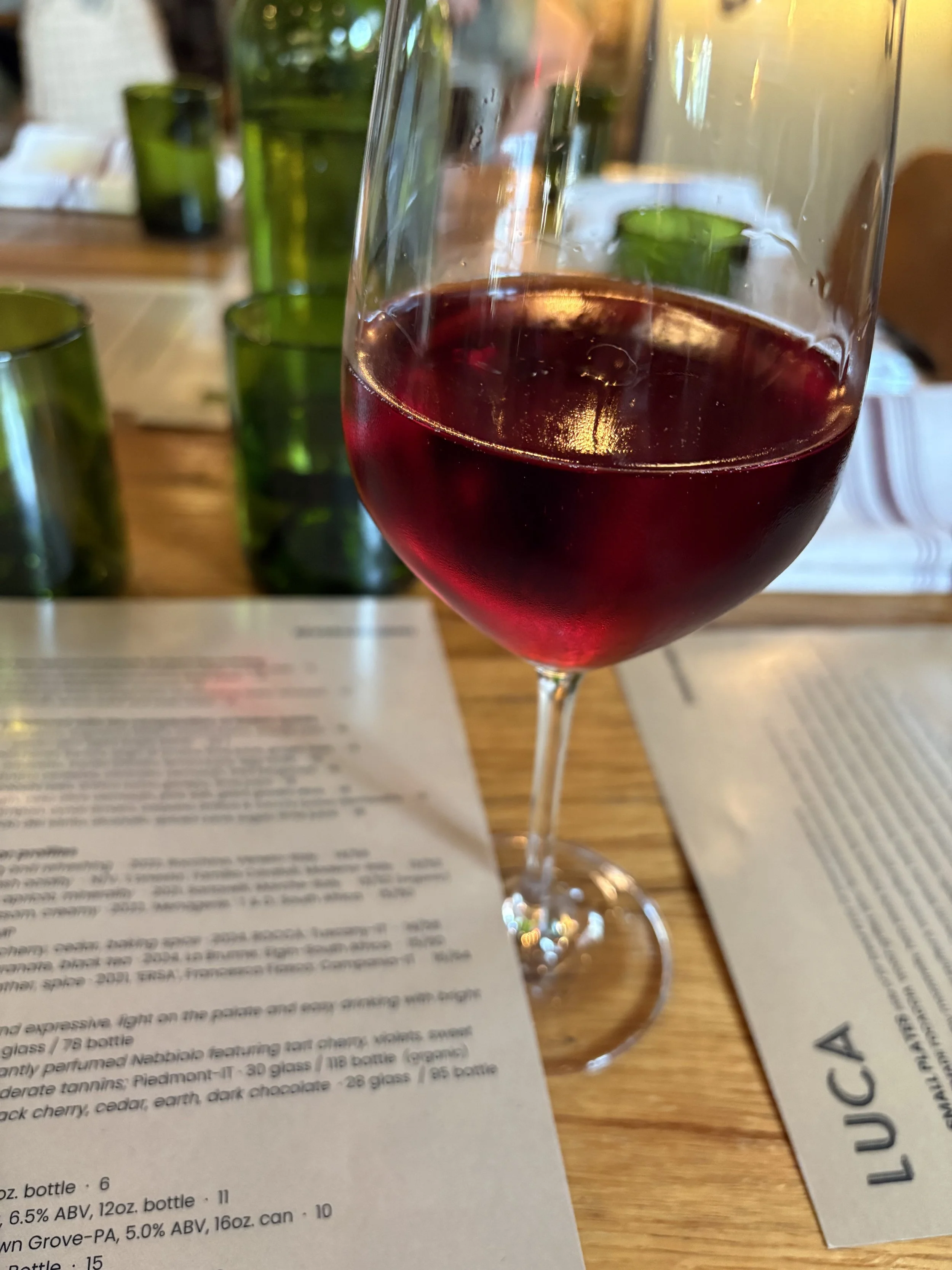 Glass of red wine served on a table during a relaxed summer dining experience