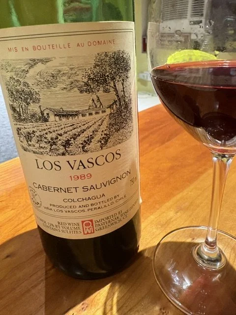 Bottle of 1989 Los Vascos Cabernet Sauvignon from Chile beside a glass of red wine, featured in a story about an unexpectedly excellent aged wine.