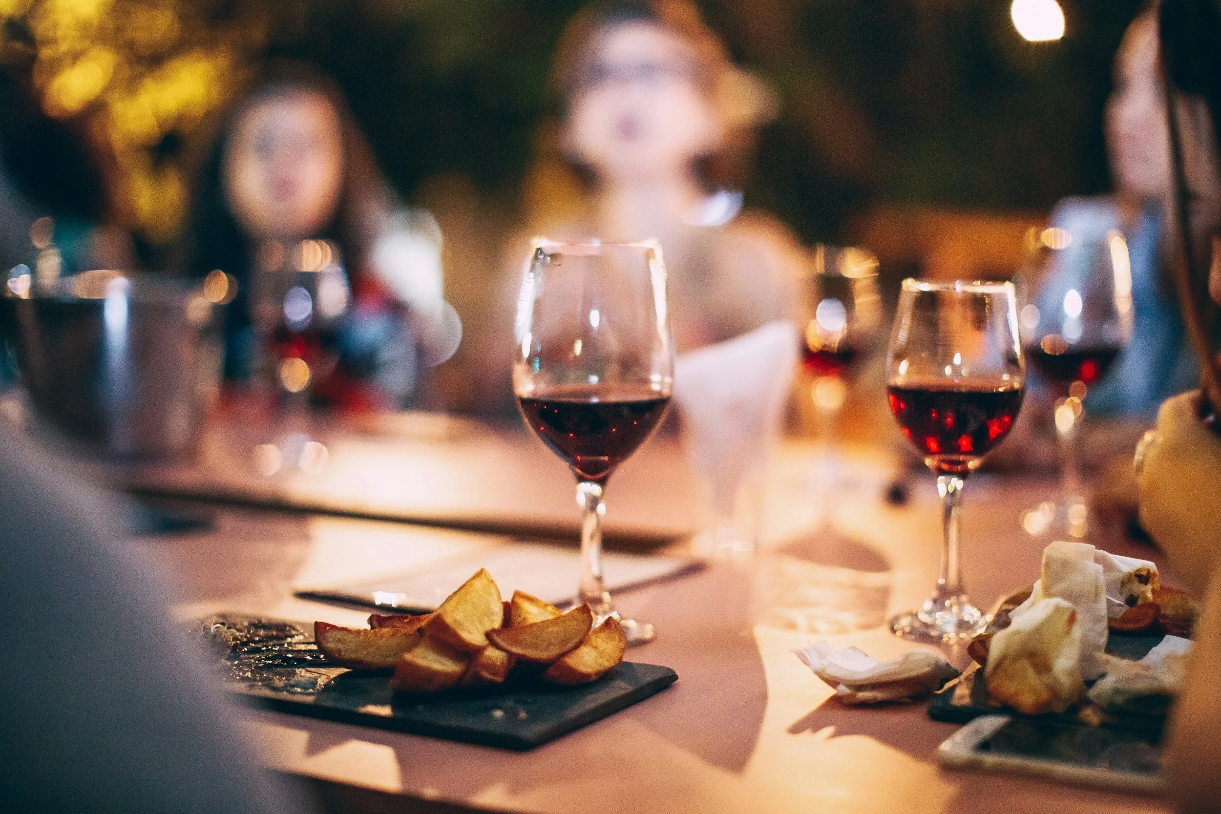 Guests enjoying wine with cheese and light appetizers during a home wine tasting experience.