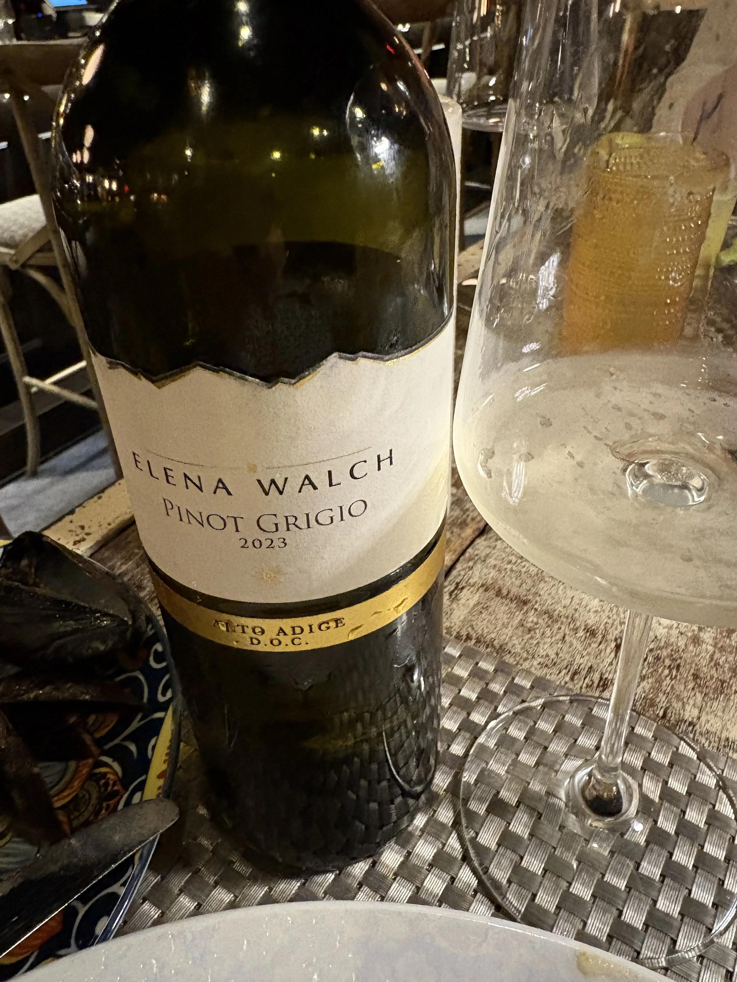 Bottle of Elena Walch Pinot Grigio from Alto Adige beside a wine glass during summer dining experience