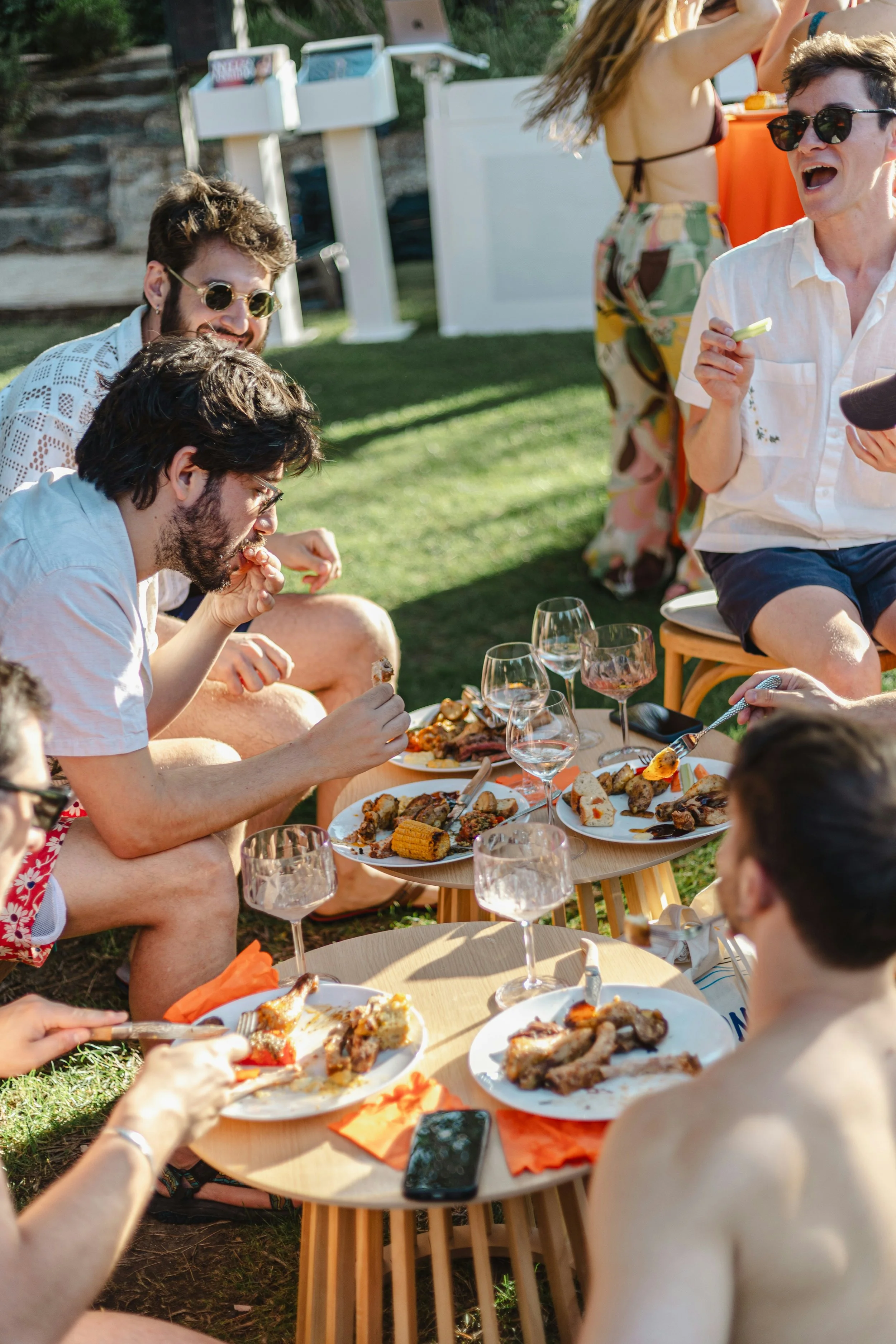 Friends enjoying grilled food and wine outdoors during a Labor Day gathering
