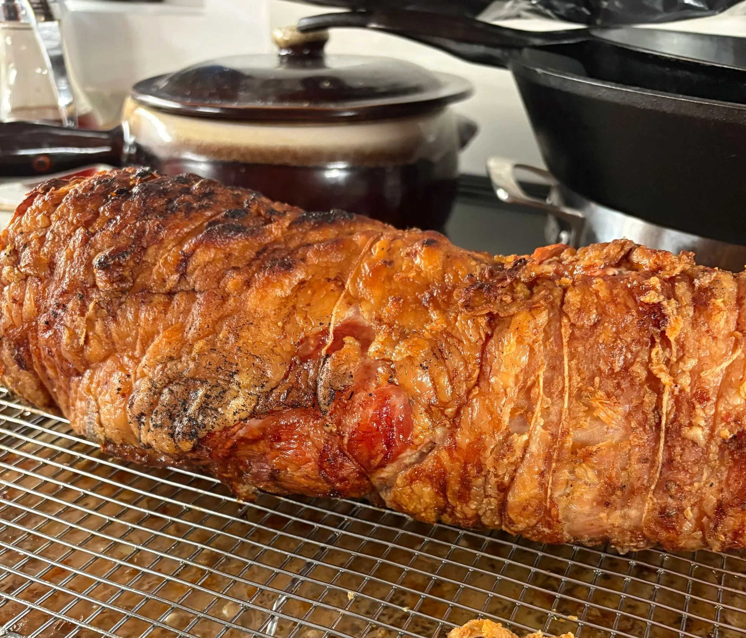 Grilled porchetta resting on a rack.