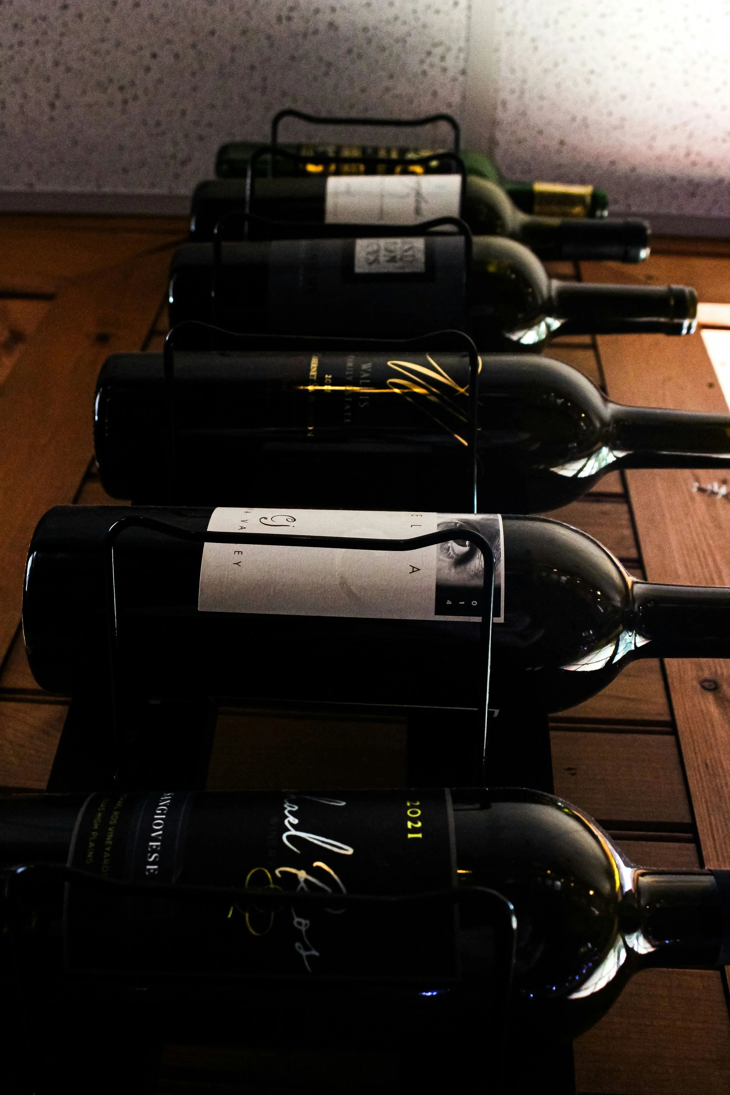 Selection of curated wine bottles displayed on a wooden table representing thoughtful wine exploration and boutique wine selections