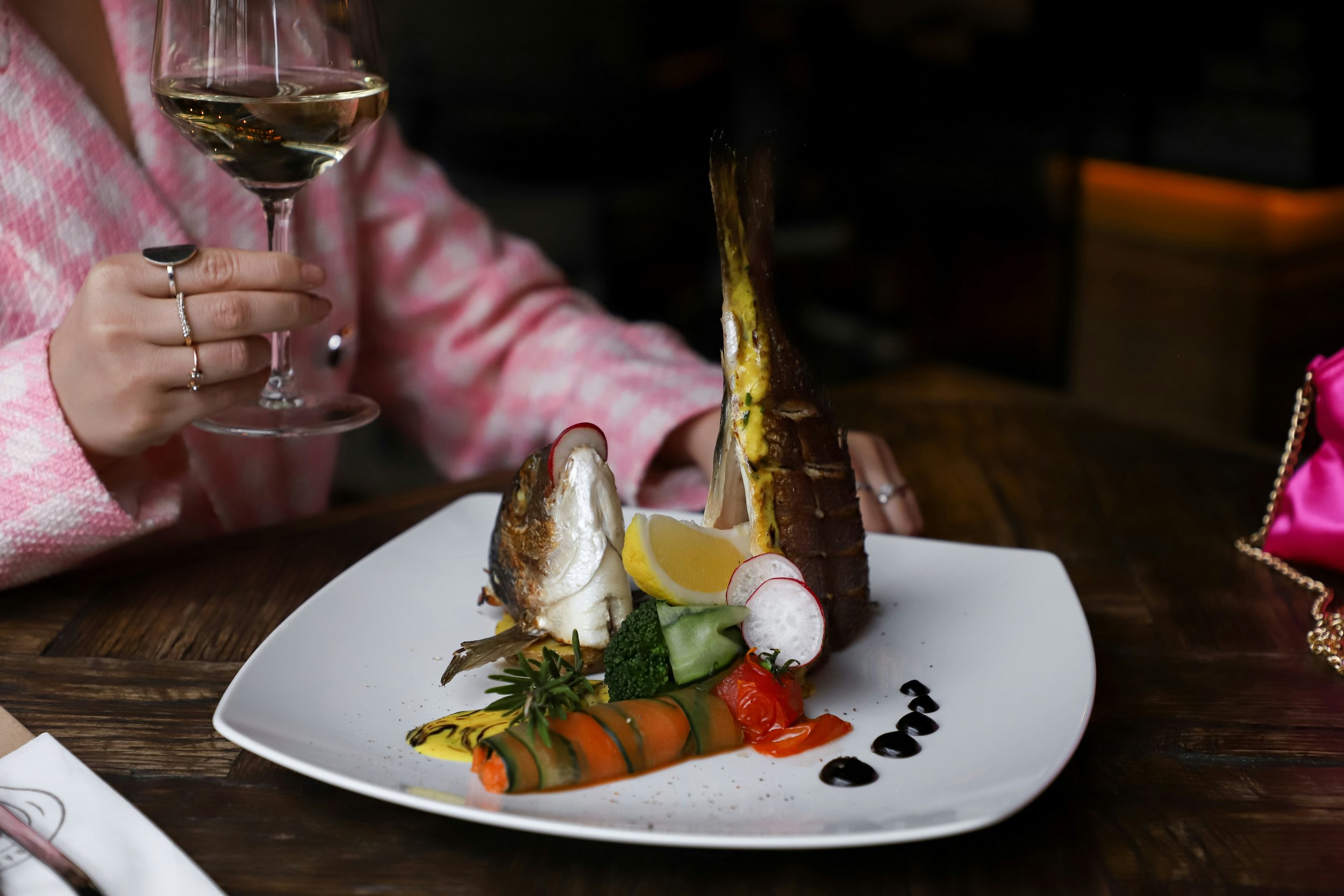 Elegant fish dinner paired with a glass of white wine during a fine dining wine and food pairing experience