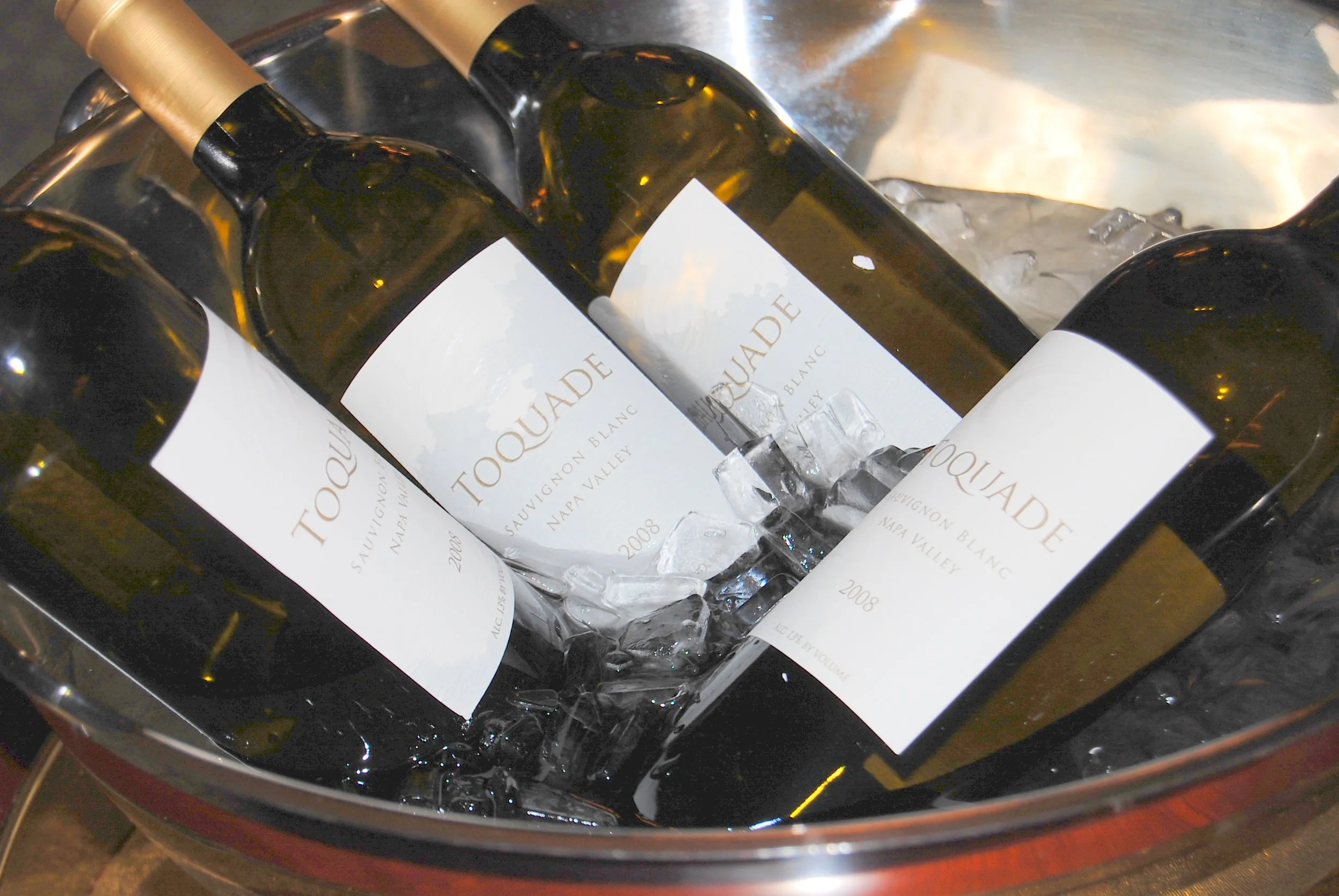 White wine bottles in an ice bucket with ice and water, demonstrating proper chilling for correct serving temperature