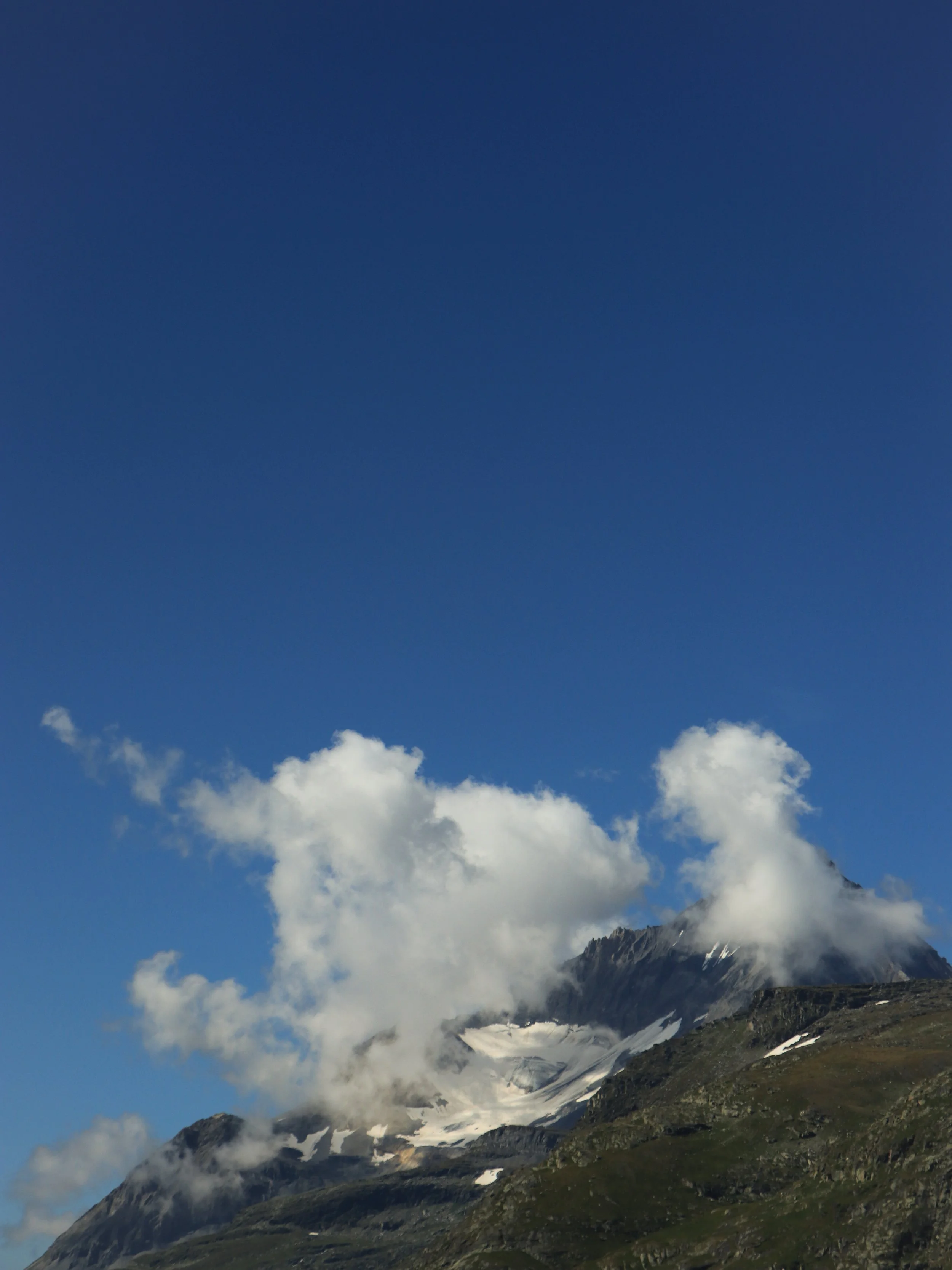 Montagne enneigée avec nuages et ciel bleu