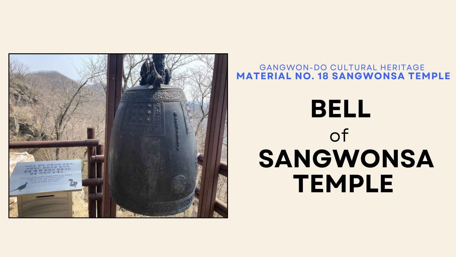 Photo of a large, ornate bell with intricate designs, displayed outdoors at Sangwonsa Temple with trees and mountains in the background.