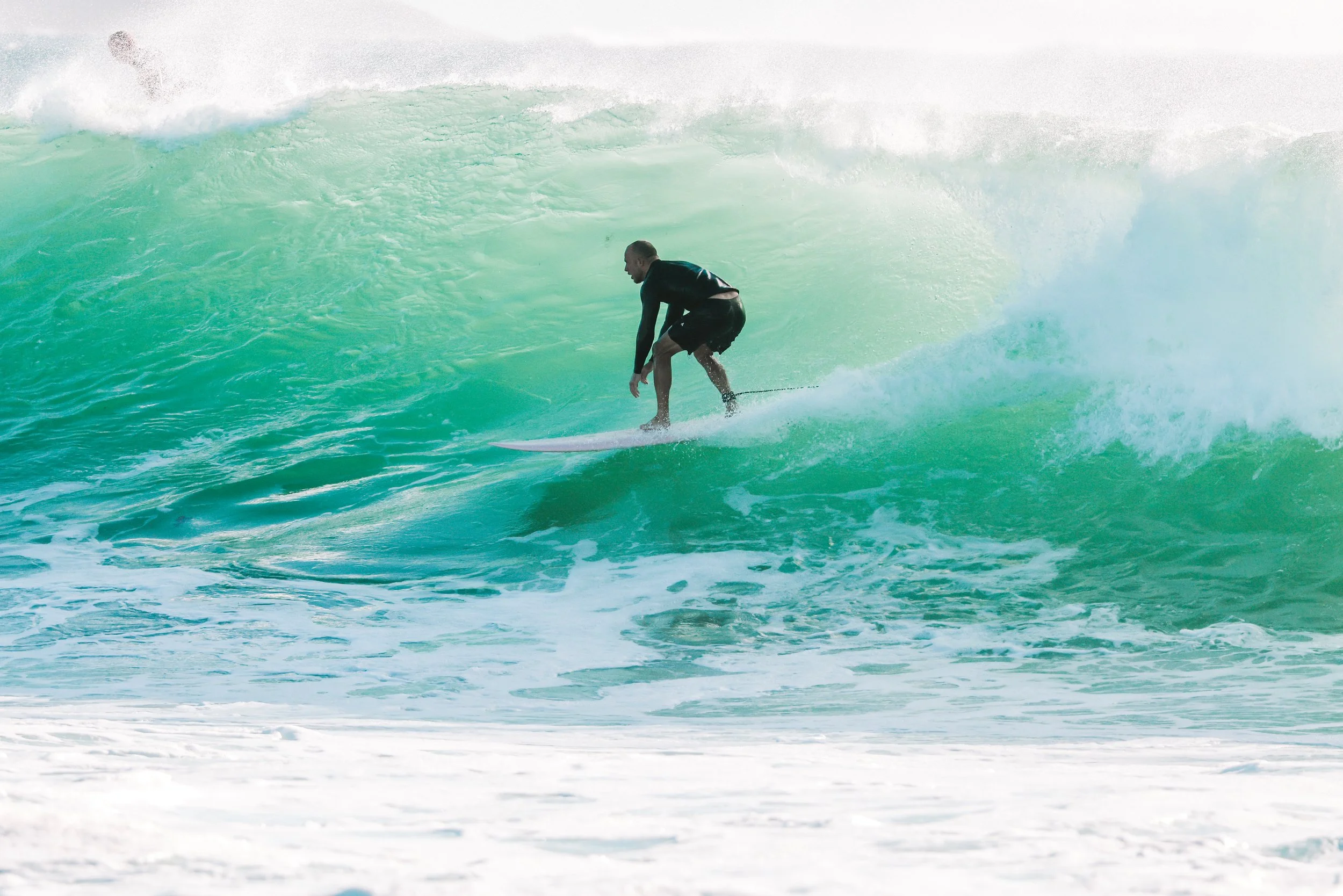 A man surfing on a wave in the ocean.