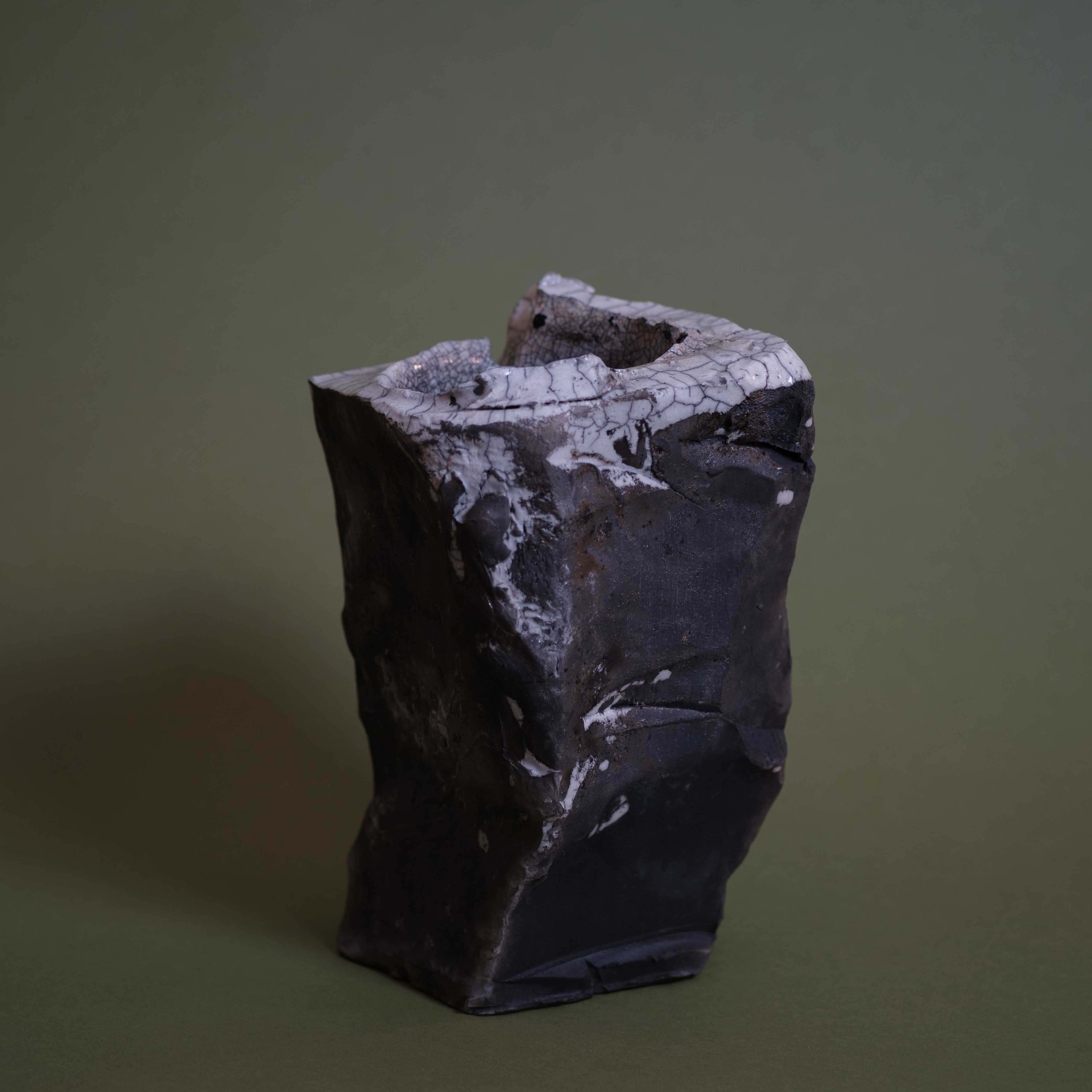 Side view of Rock Vessel sculptural pottery highlighting its monolithic silhouette and textured clay surface