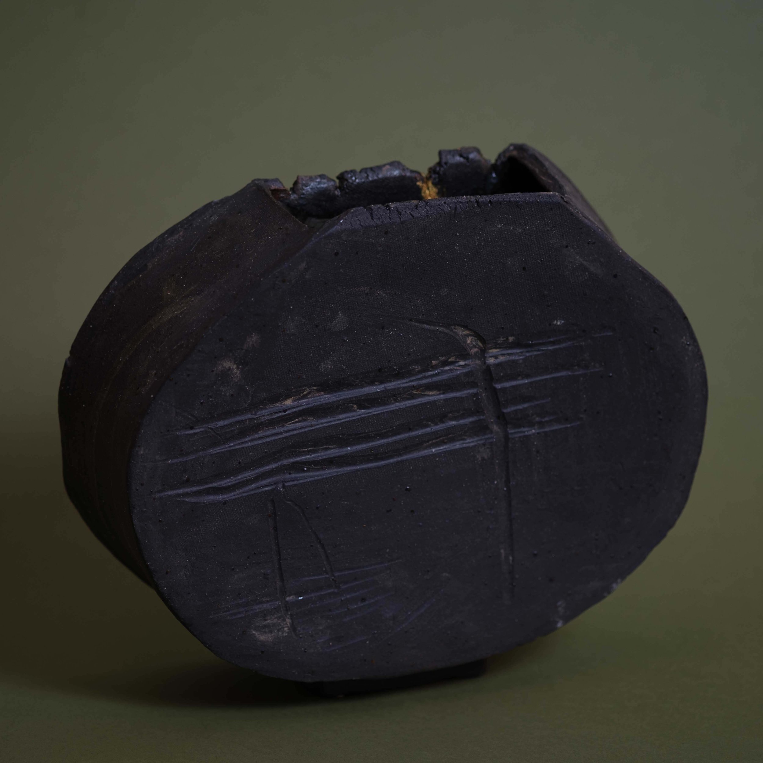 Side view of Dusty Line Vessel sculptural pottery highlighting its organic rounded shape and textured clay finish