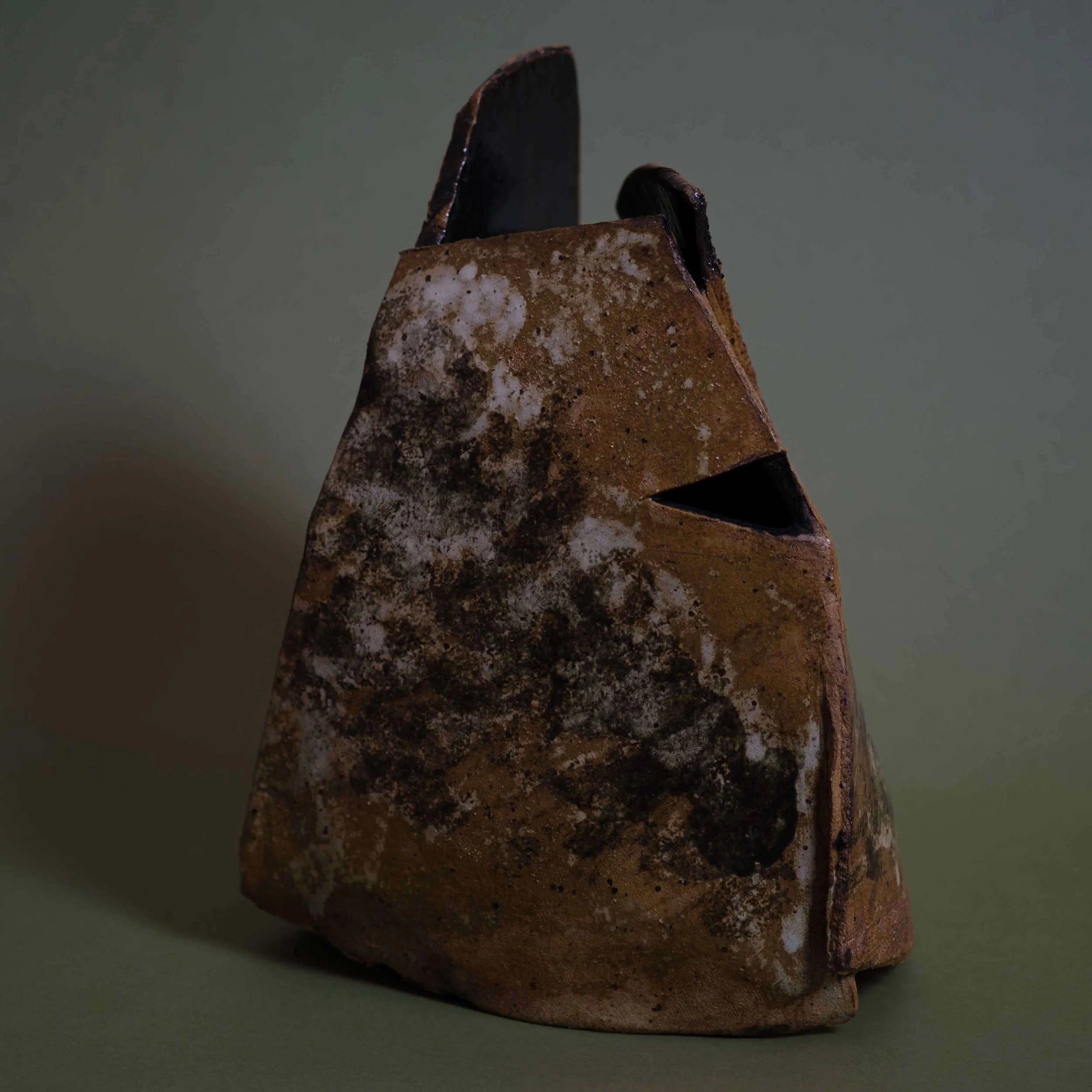 Side view of Drifted Shape sculptural pottery highlighting its sharp cut opening and rock-like architectural silhouette