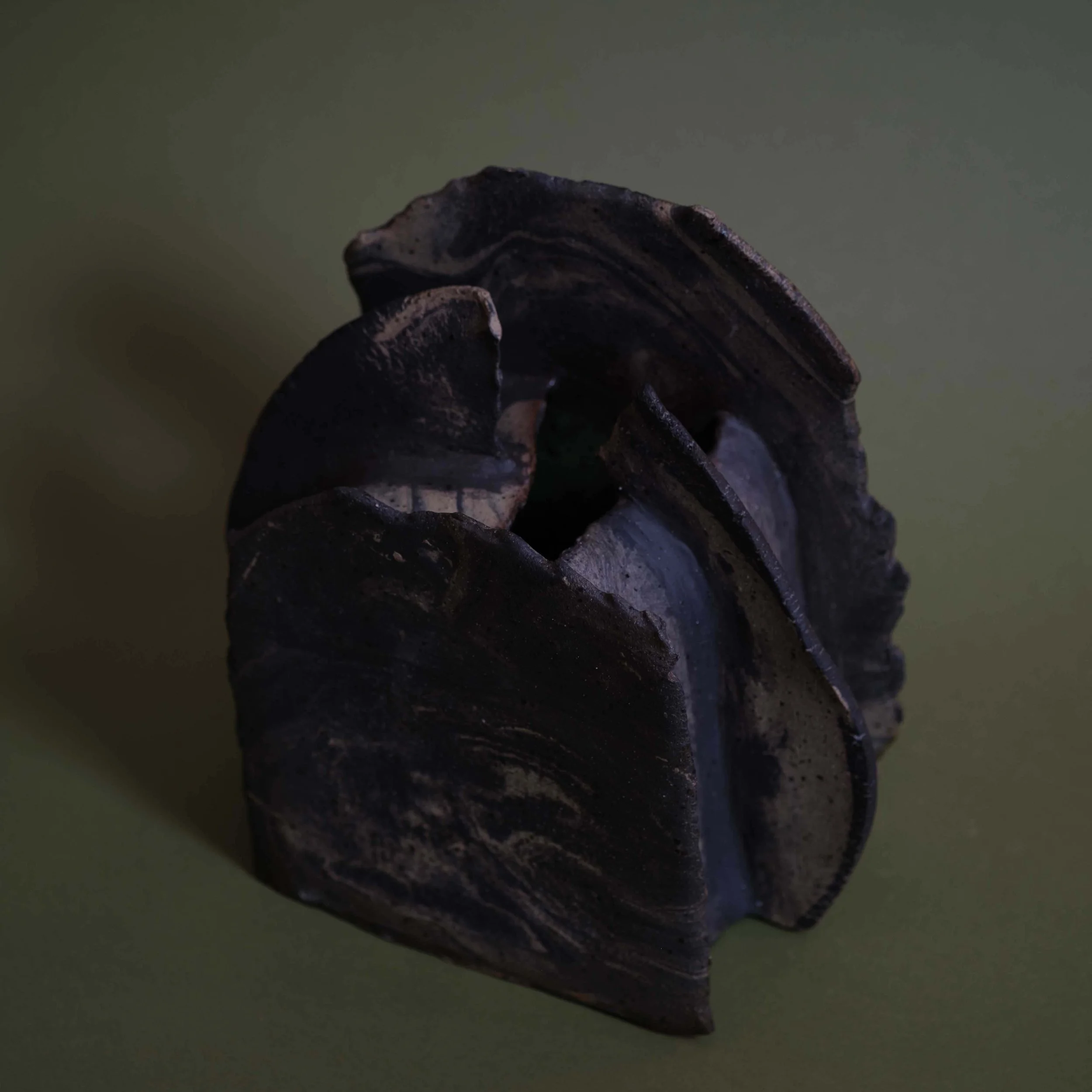 Side view of Mountain Vessel sculptural pottery showing layered organic form and textured hand-built clay surface