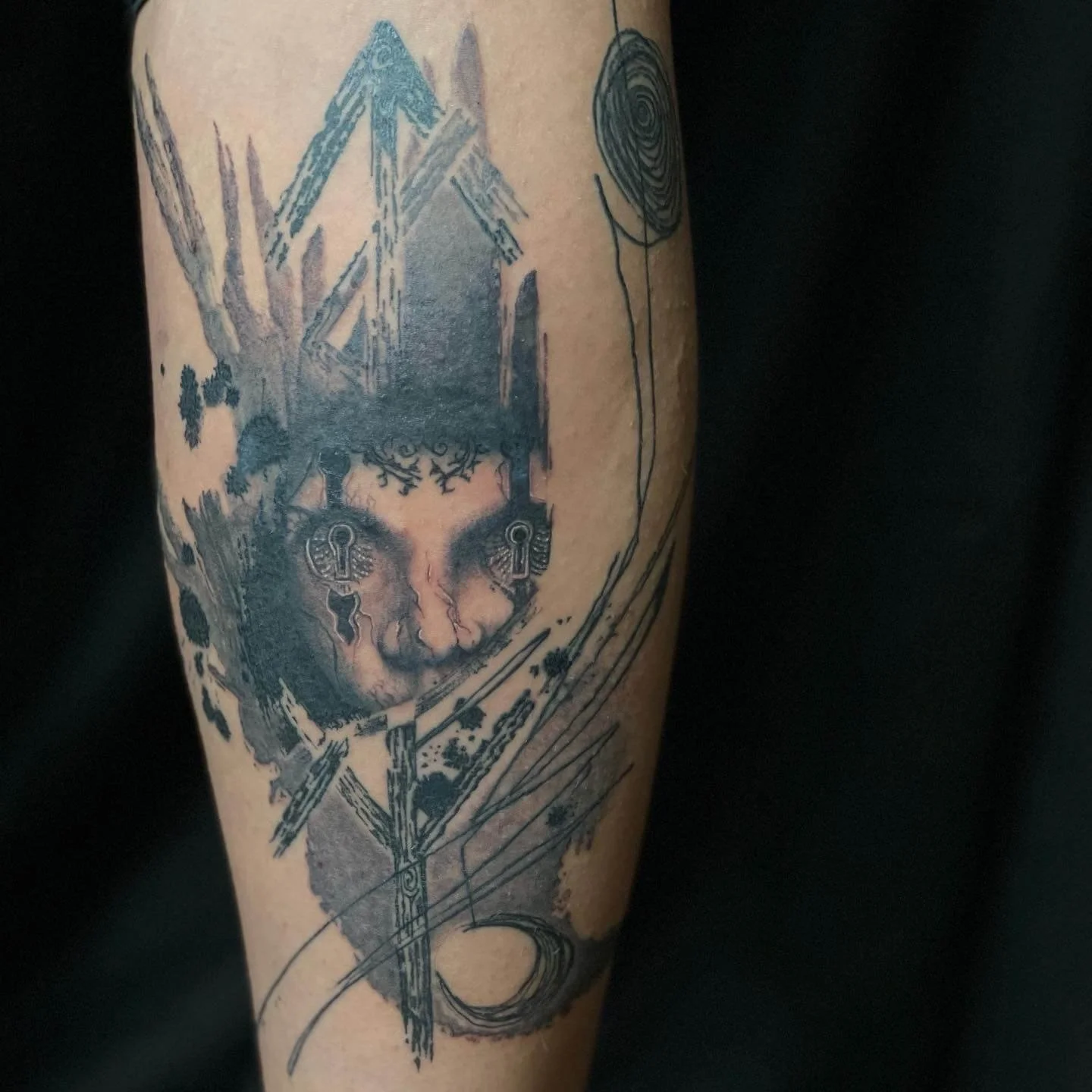 Contemporary abstract portrait tattoo combining mechanical features and fluid geometric composition.