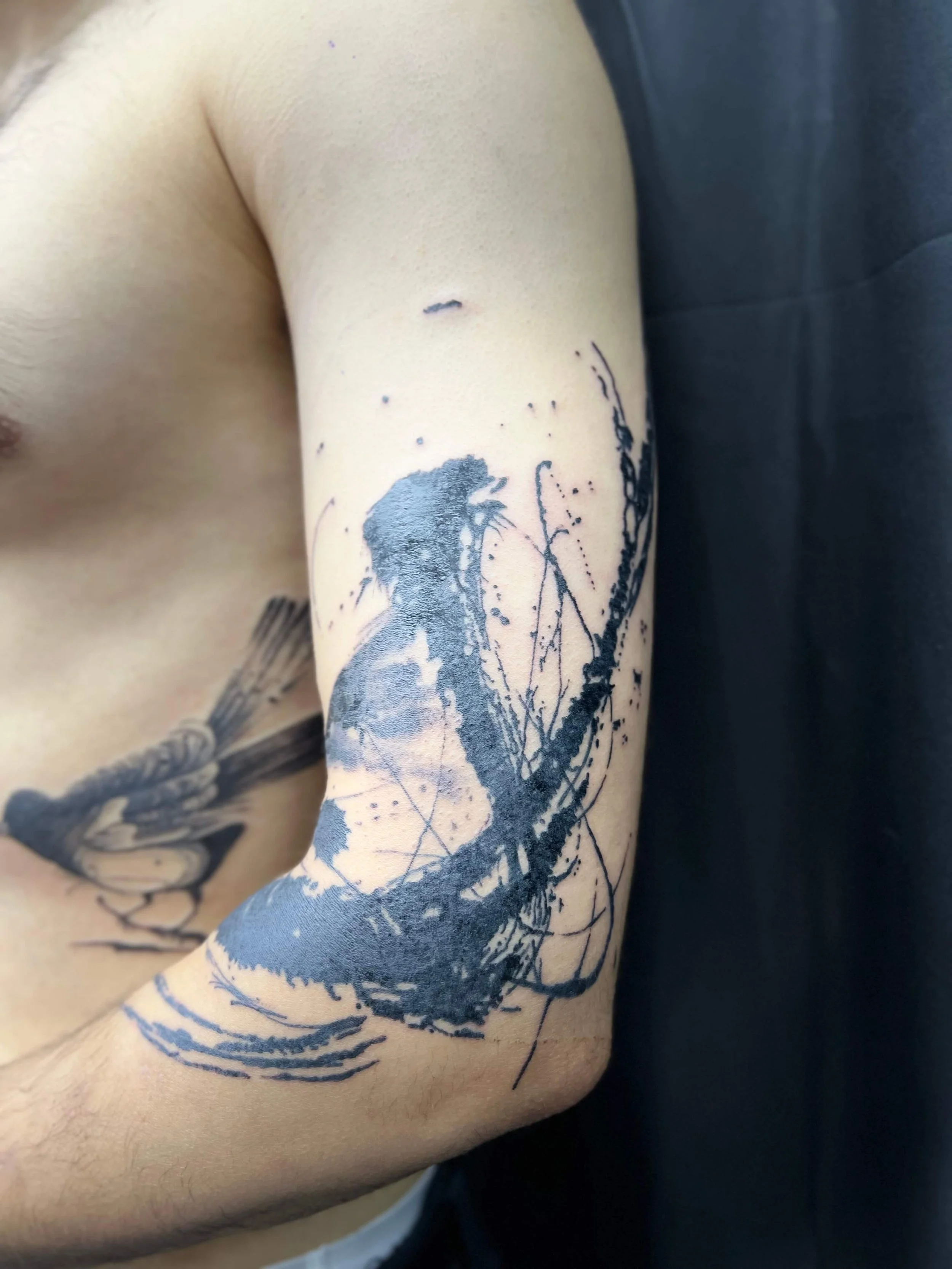 Contemporary abstract symbol tattoo in clean black ink composition.