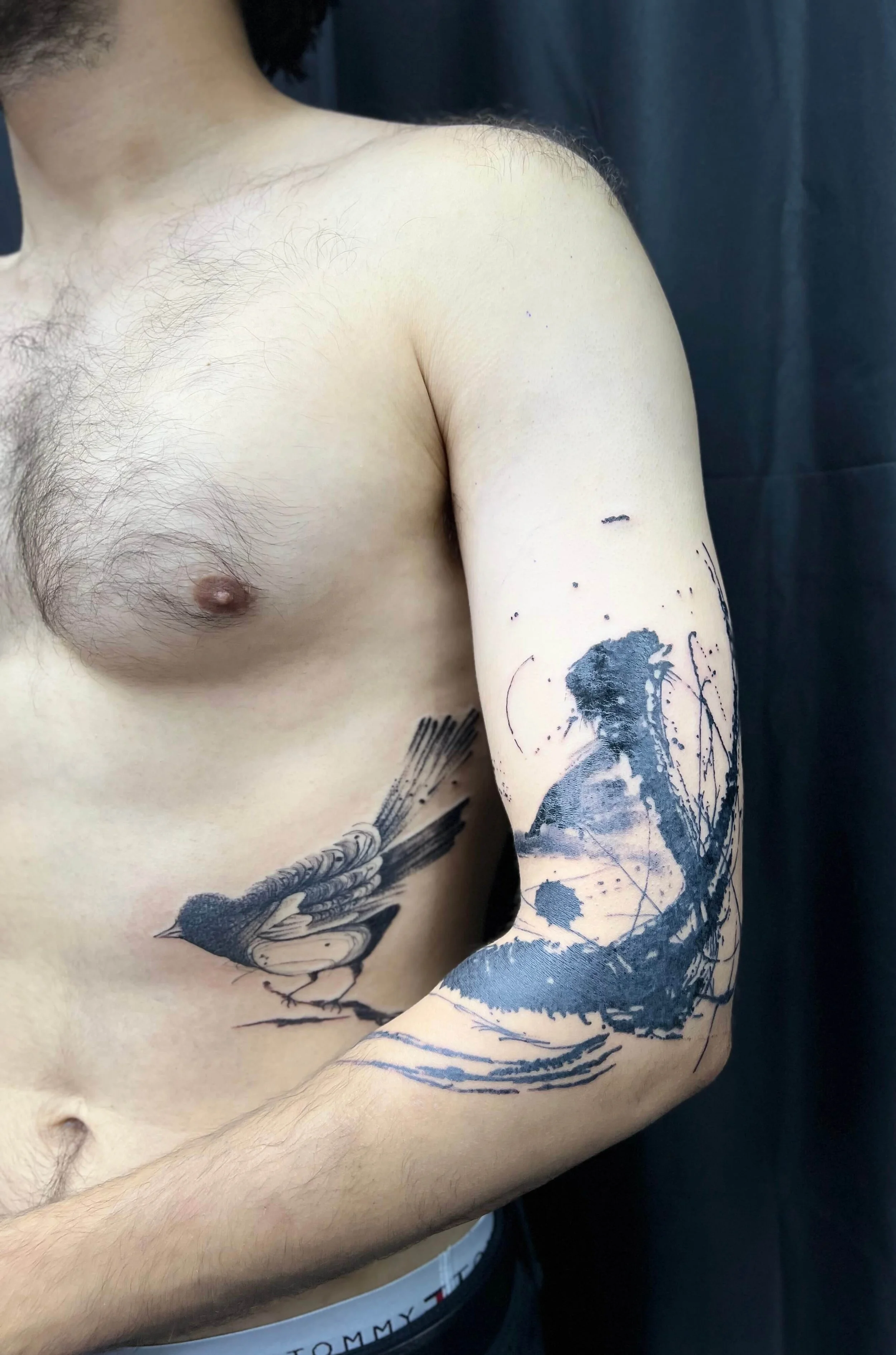 Contemporary abstract arm tattoo in black ink with layered structural composition.