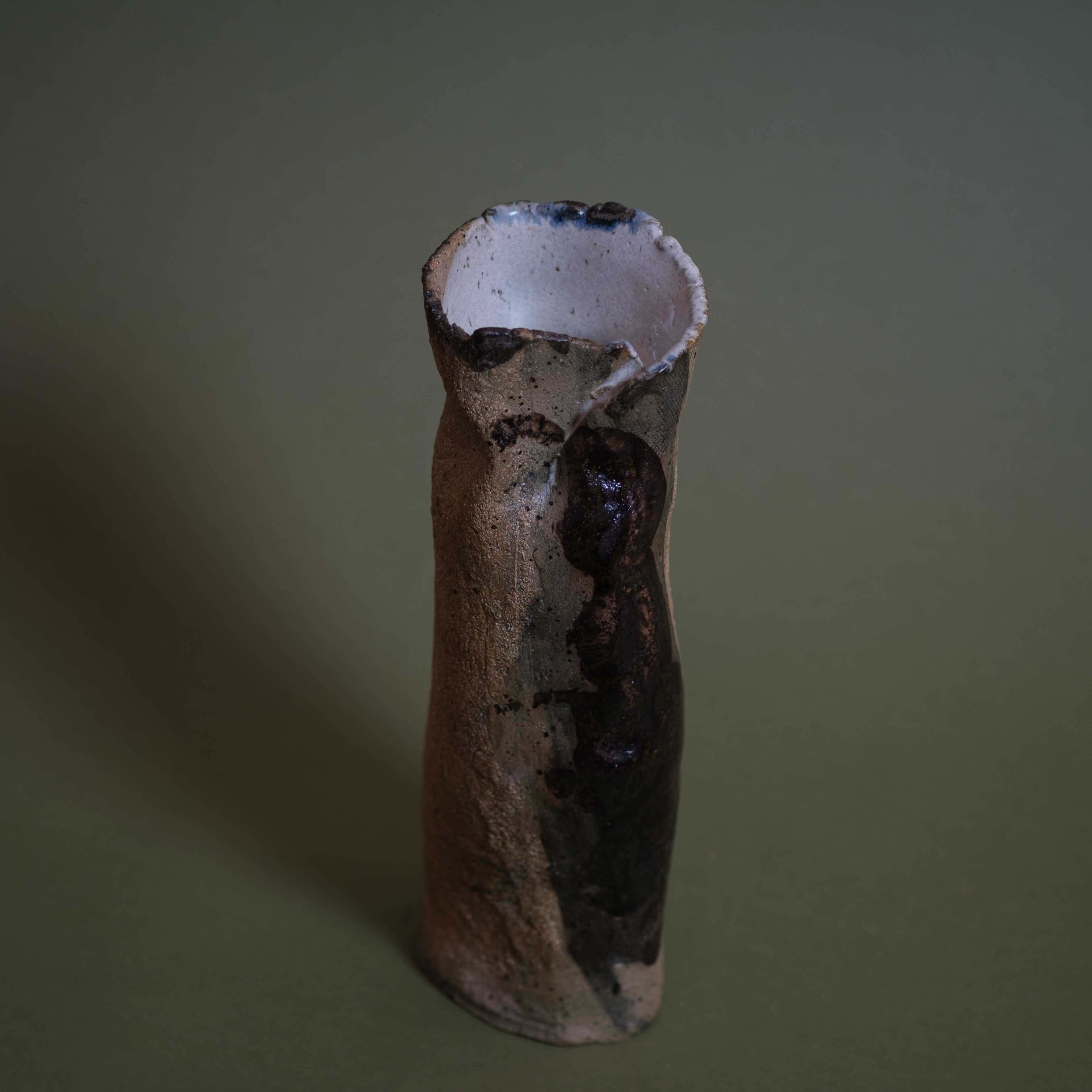 Detail of Tall Yellow Vessel handmade ceramic artwork showing earthy glaze variations and rough sculpted rim