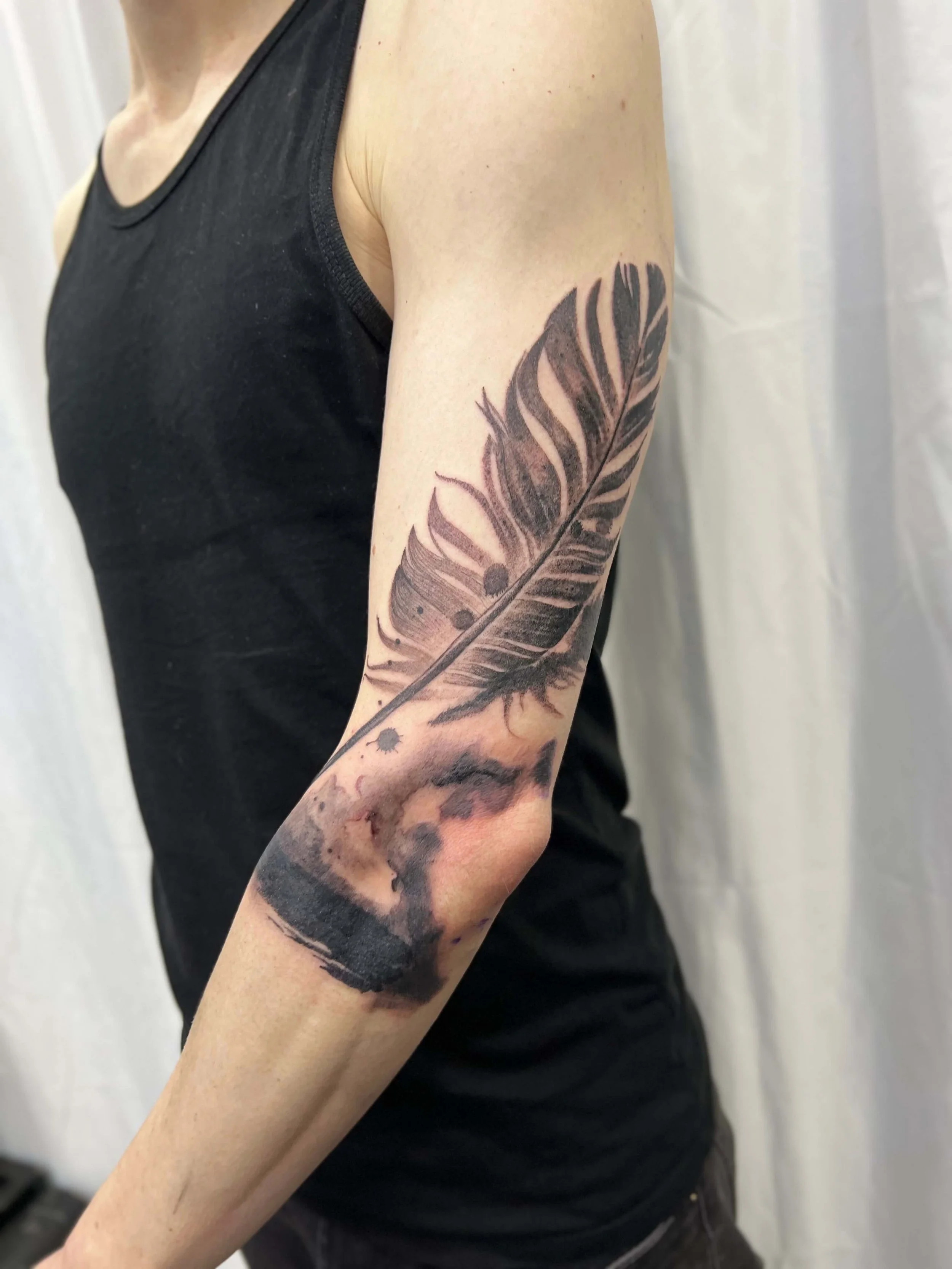 Contemporary blackwork feather design with fluid, painterly ink effects.