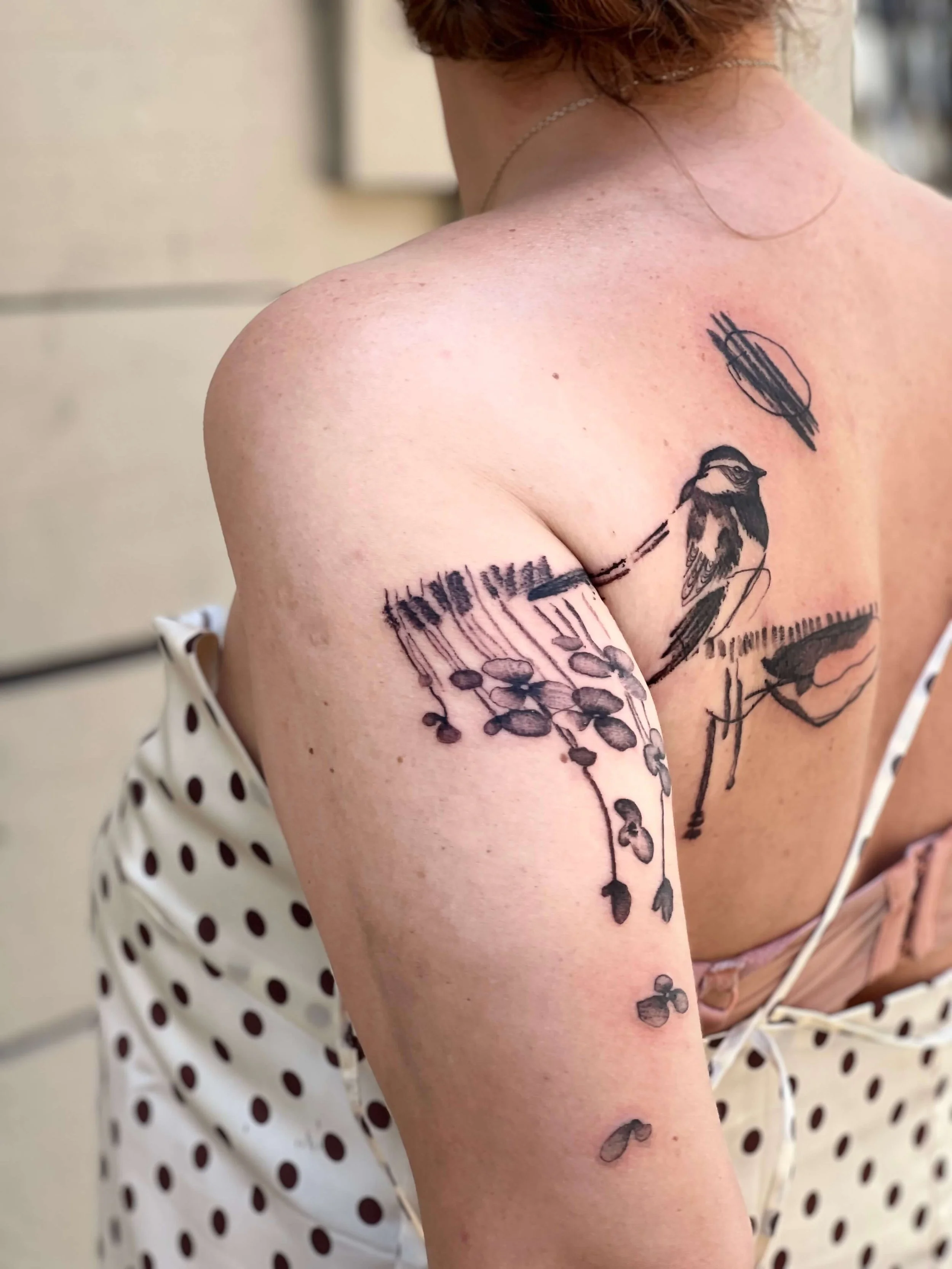 Abstract blackwork shoulder tattoo blending natural motifs with structural and organic line composition.