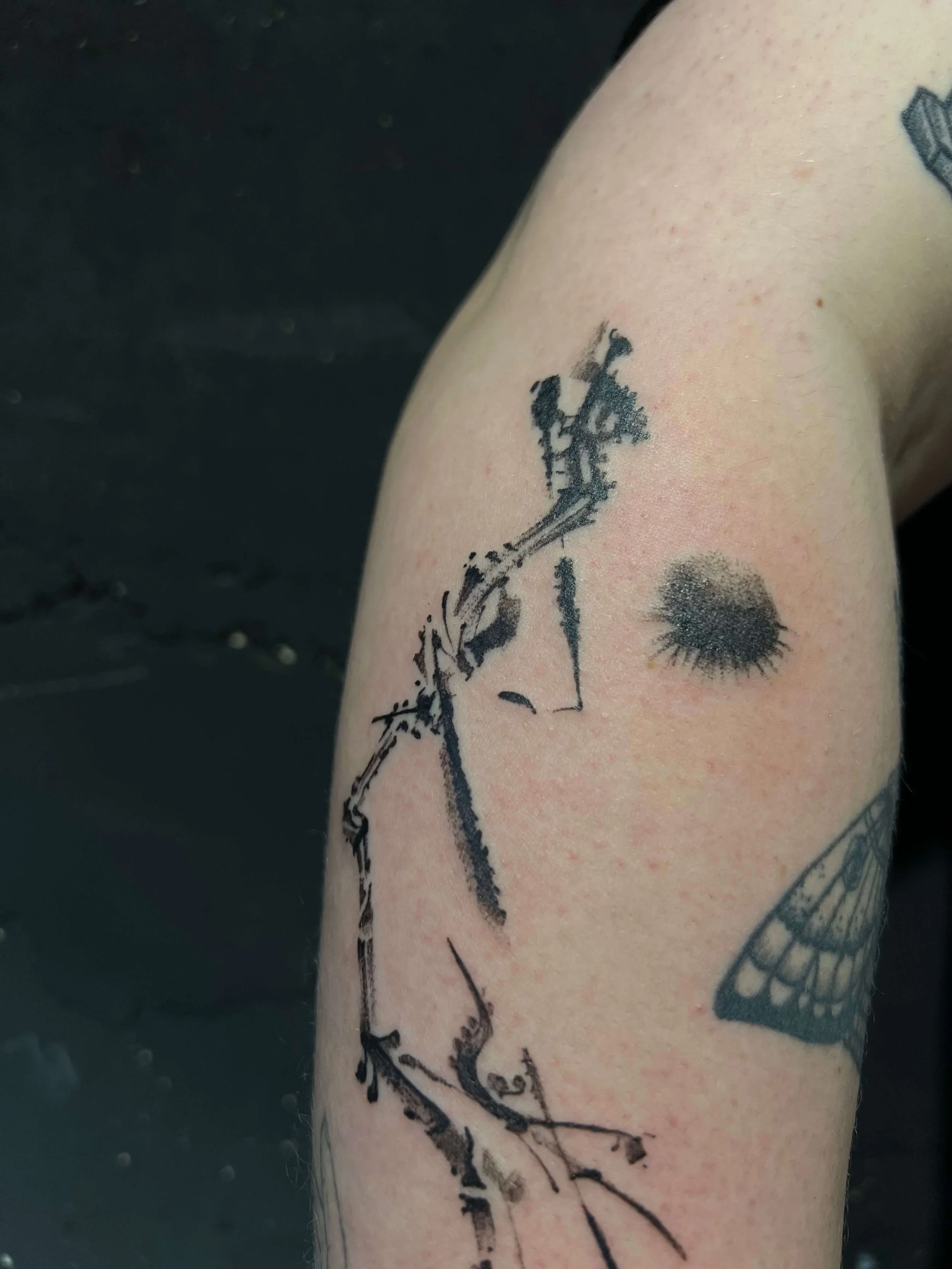 Contemporary abstract arm tattoo blending delicate linework with graphic ink accents.