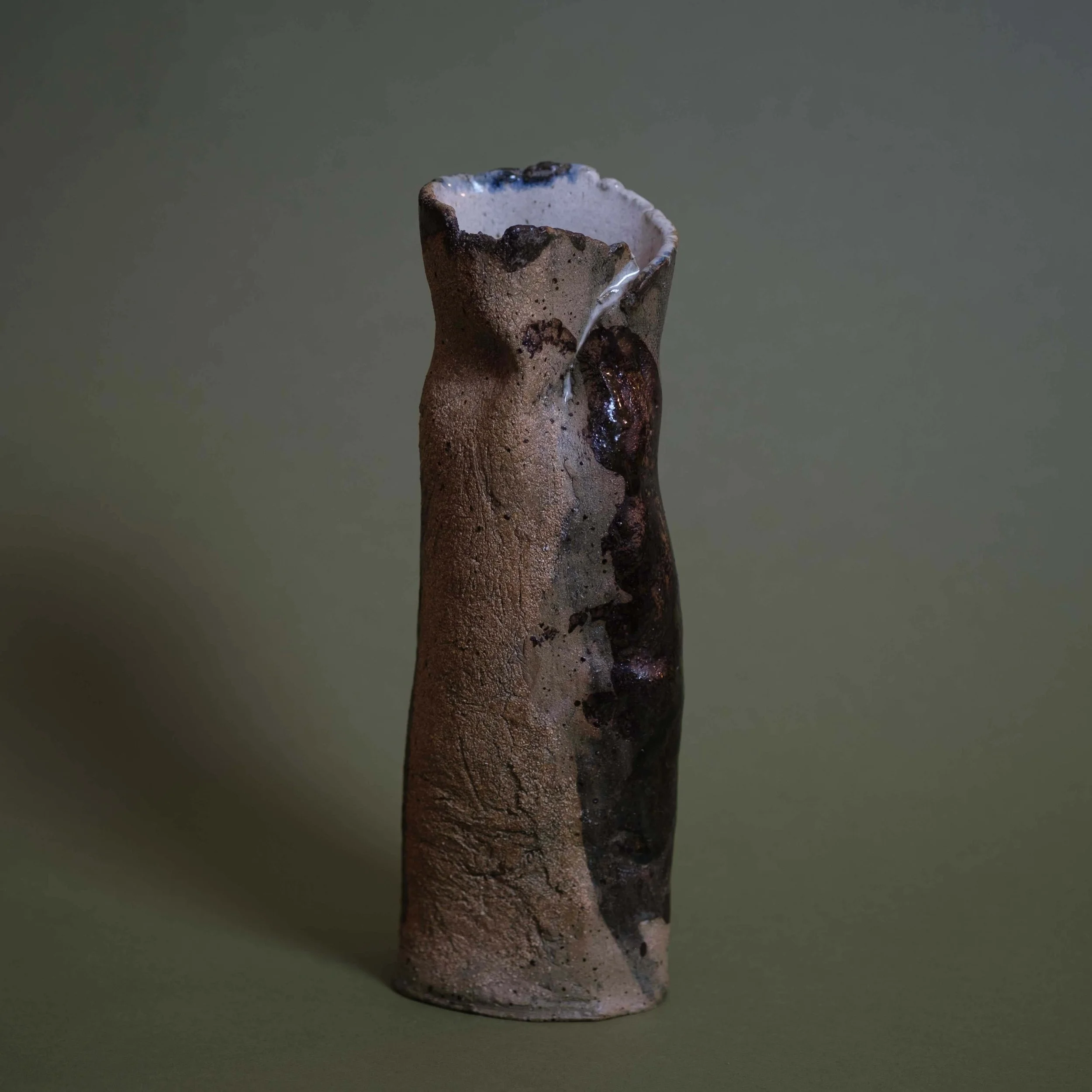 Side view of Tall Yellow Vessel sculptural pottery highlighting its elongated silhouette and natural clay texture
