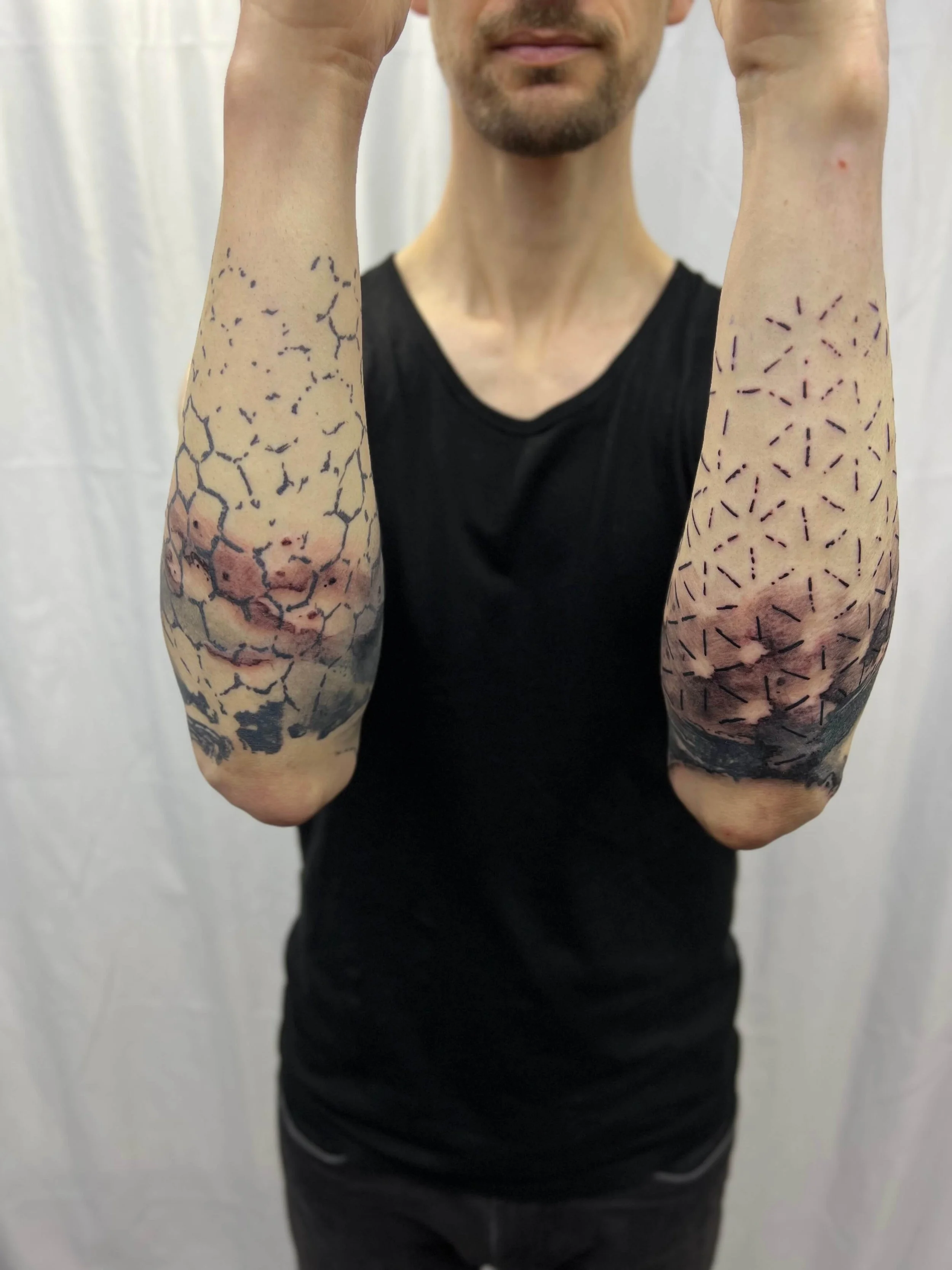 Blackwork forearm tattoos featuring detailed illustrative compositions in contemporary style.