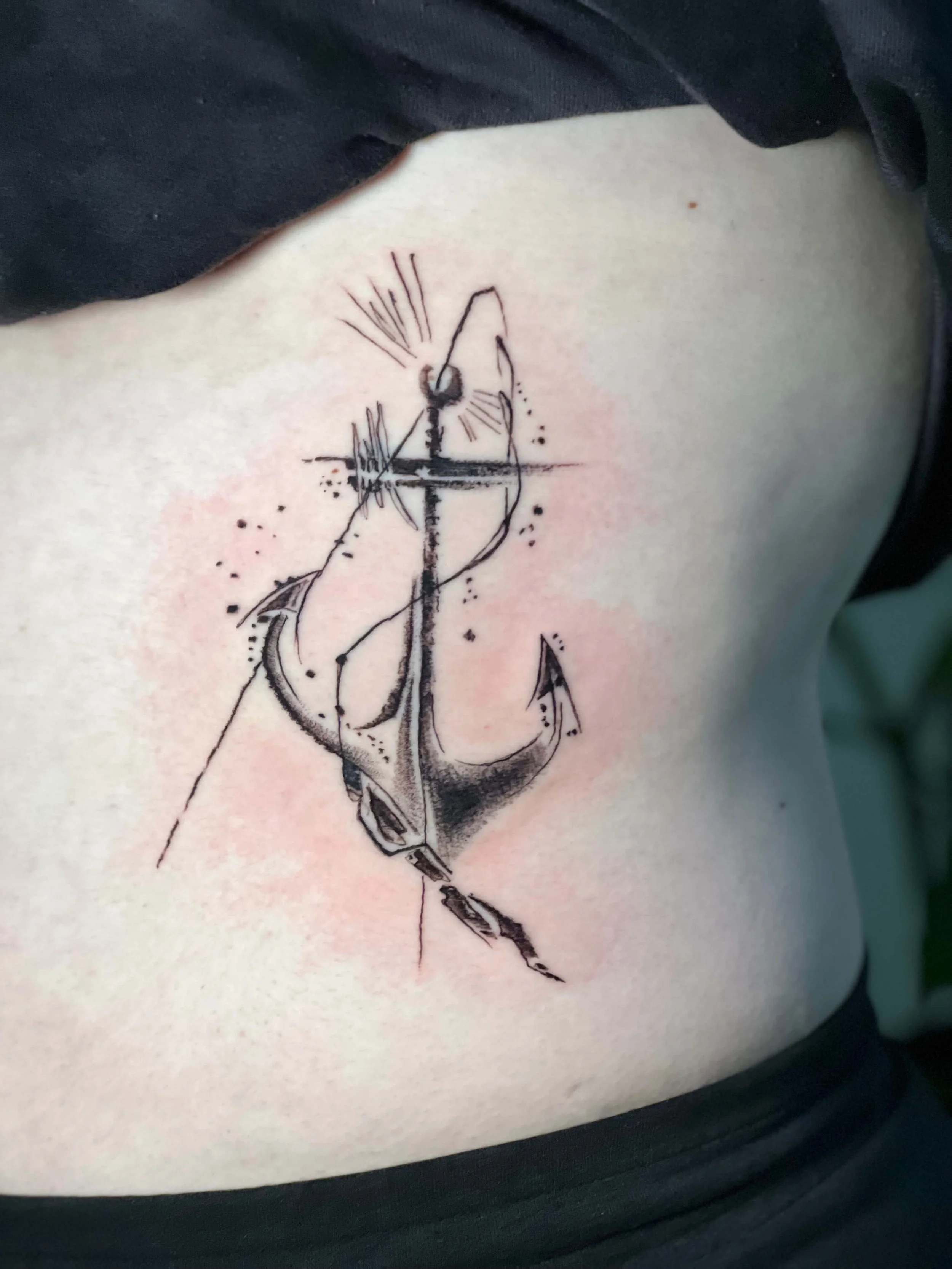 Abstract black ink anchor tattoo with geometric detailing and contemporary composition.