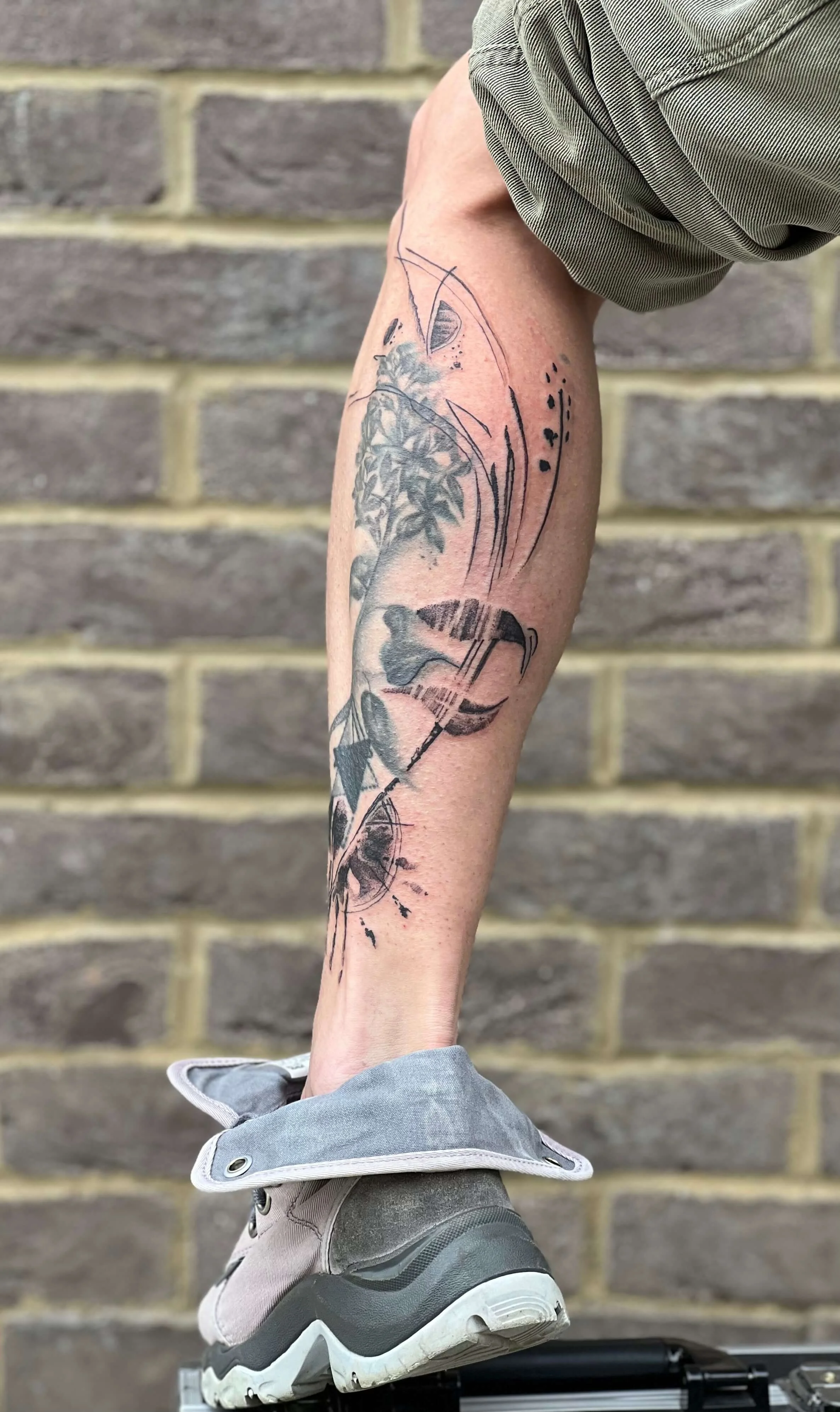 Abstract black tattoo with expressive ink splatter detailing.