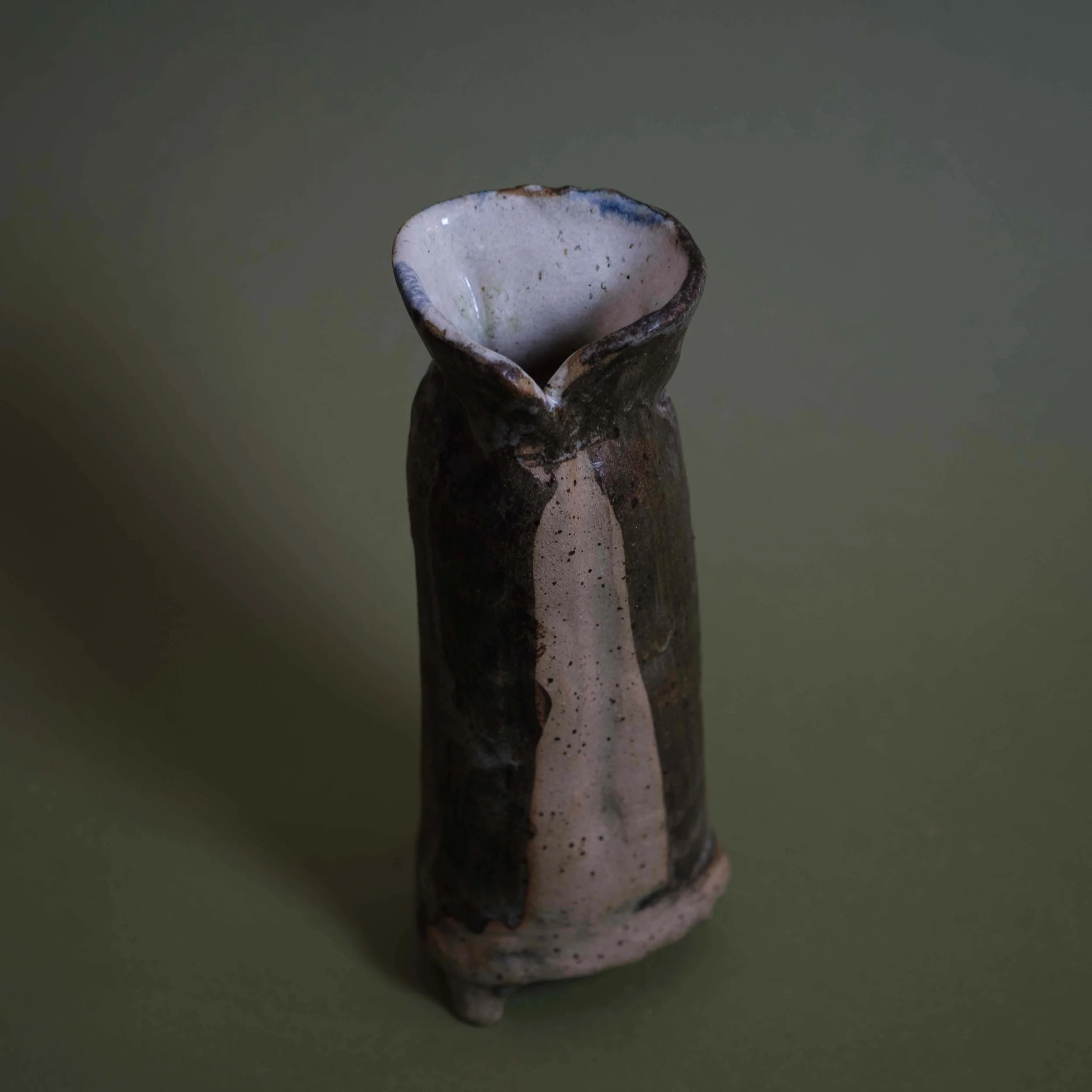 Detail of Tall Green Vessel handmade ceramic artwork showing layered clay construction and natural glaze texture