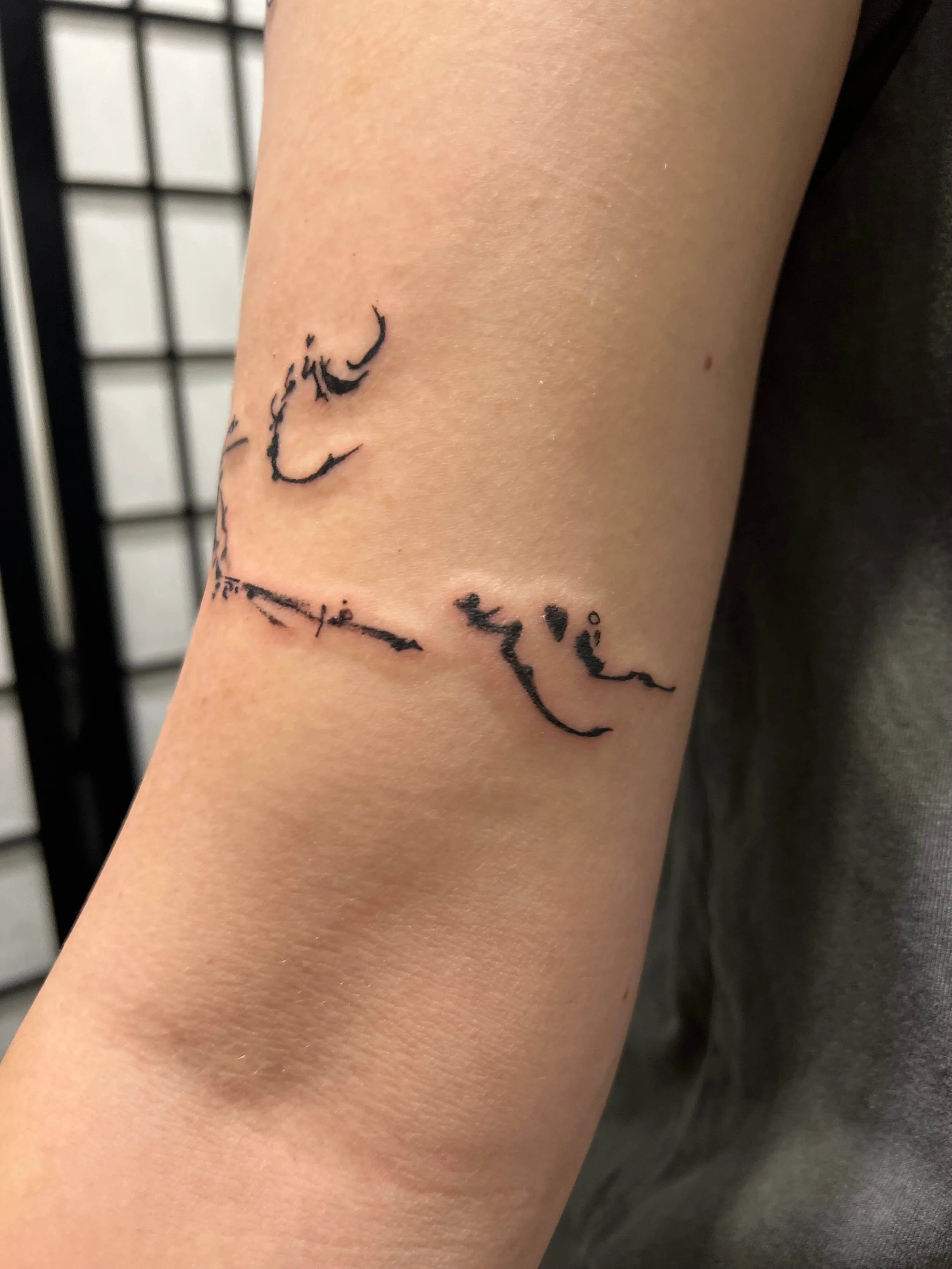 Contemporary black ink lettering tattoo with refined minimalist composition.